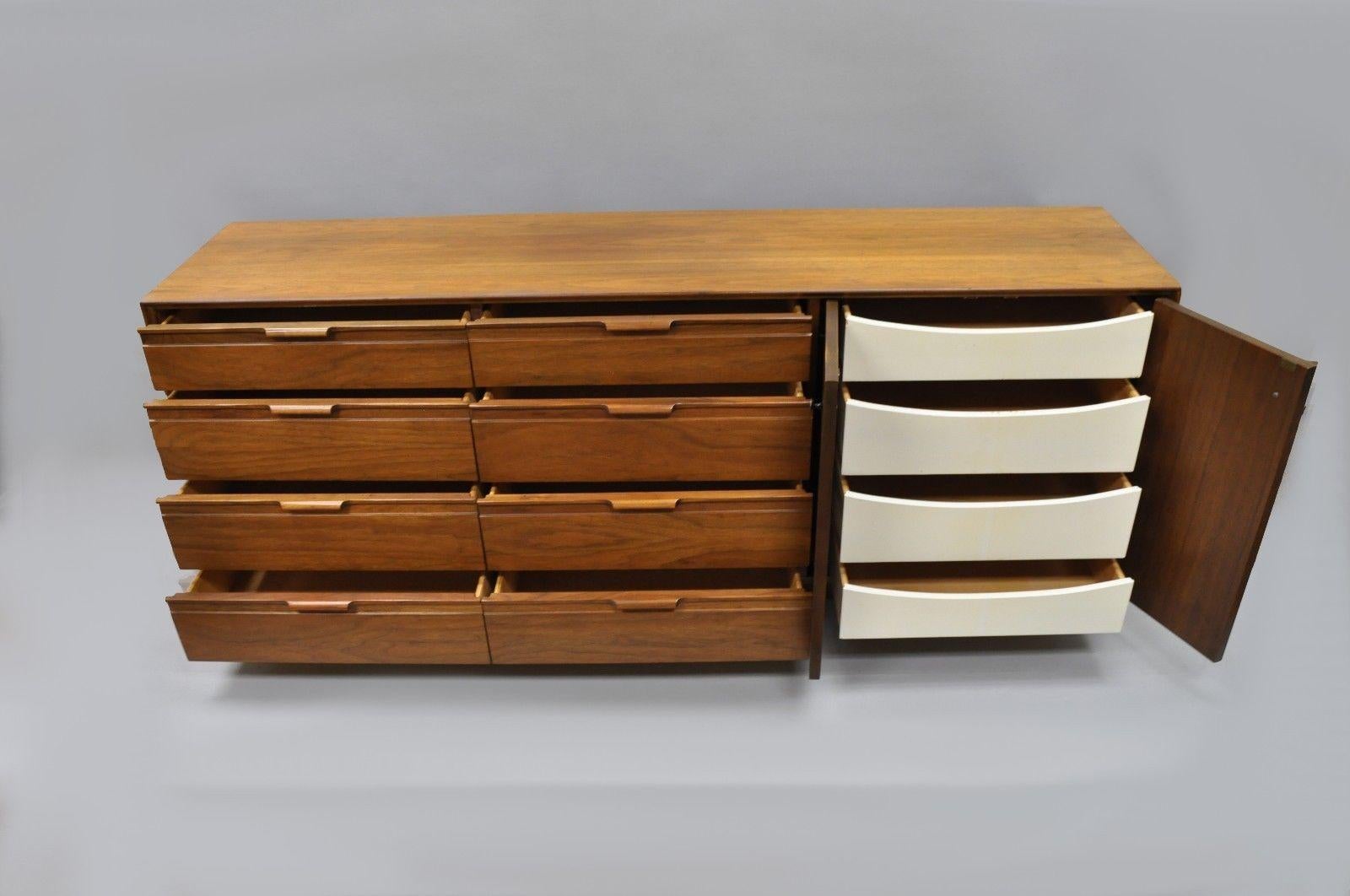 Vintage Mid-Century Modern walnut 12 drawer dresser by American of Martinsville. Item features sculpted wood and metal pulls, 12 dovetailed drawers, beautiful wood grain, signed inside drawer, white contrast painted concealed drawers, clean