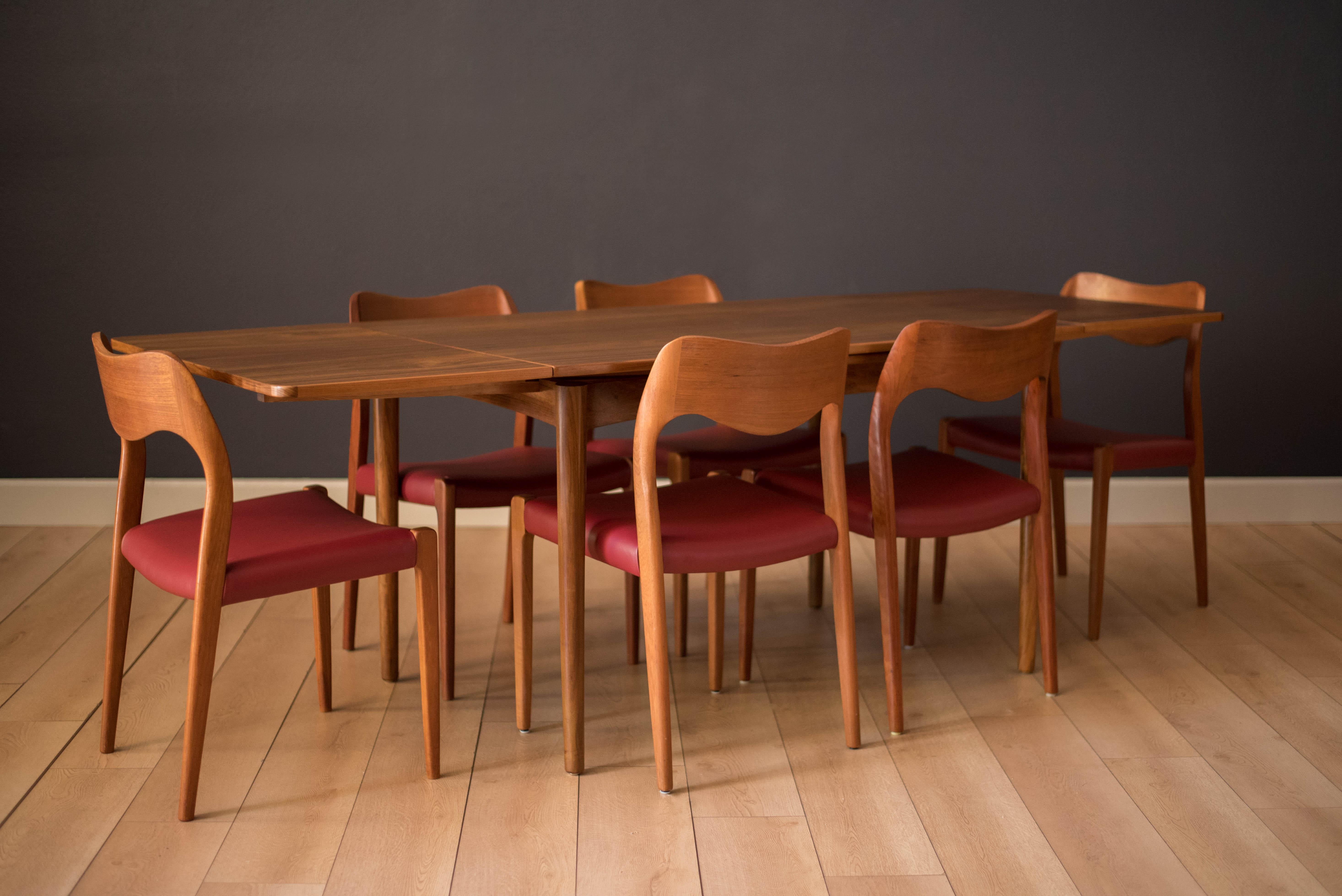 Midcentury expandable dining table designed by Arne Hovmand-Olsen for Skovmand & Andersen in walnut. This rectangular draw leaf table features a unique bow shape when leaves are extended and cleverly tuck in when not in use. 

Table fully extends