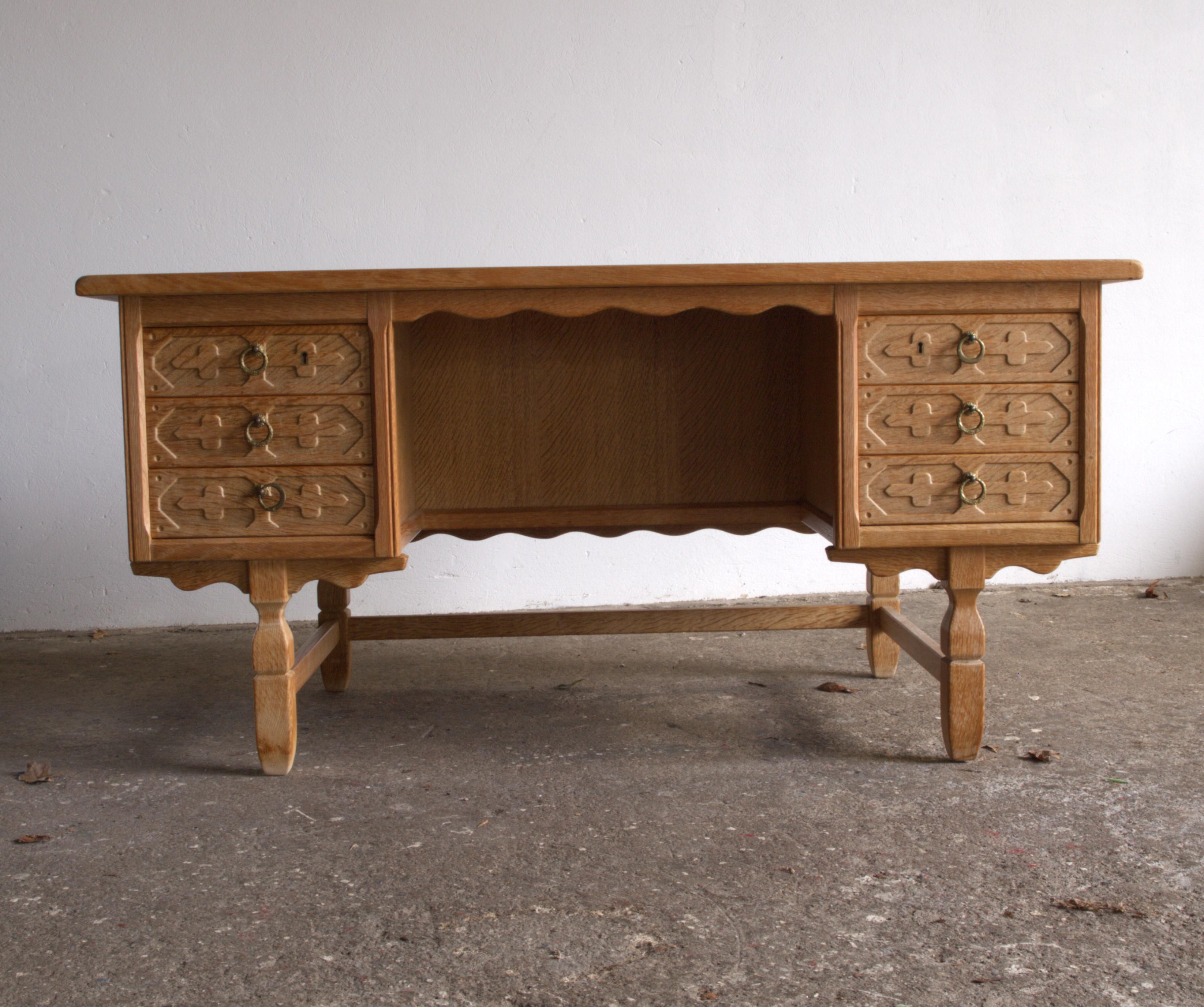 Beautiful massiv oak writing desk by Danish architect Henning (Henry) Kjærnulf. 

Danish furniture designers that gets inspiration from the time before. Style of the baroque and good woodcarved woodworking. His characteristic shaped legs in