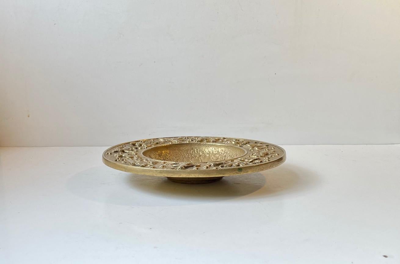 Decorative and heavy bronze bowl with Zodiac Motifs/signs and a surface that mimics the surface of the moon both to the center and the its backside. It was manufactured and designed by NM/Nordisk Malm in Denmark during the late 1940s. Stylistically