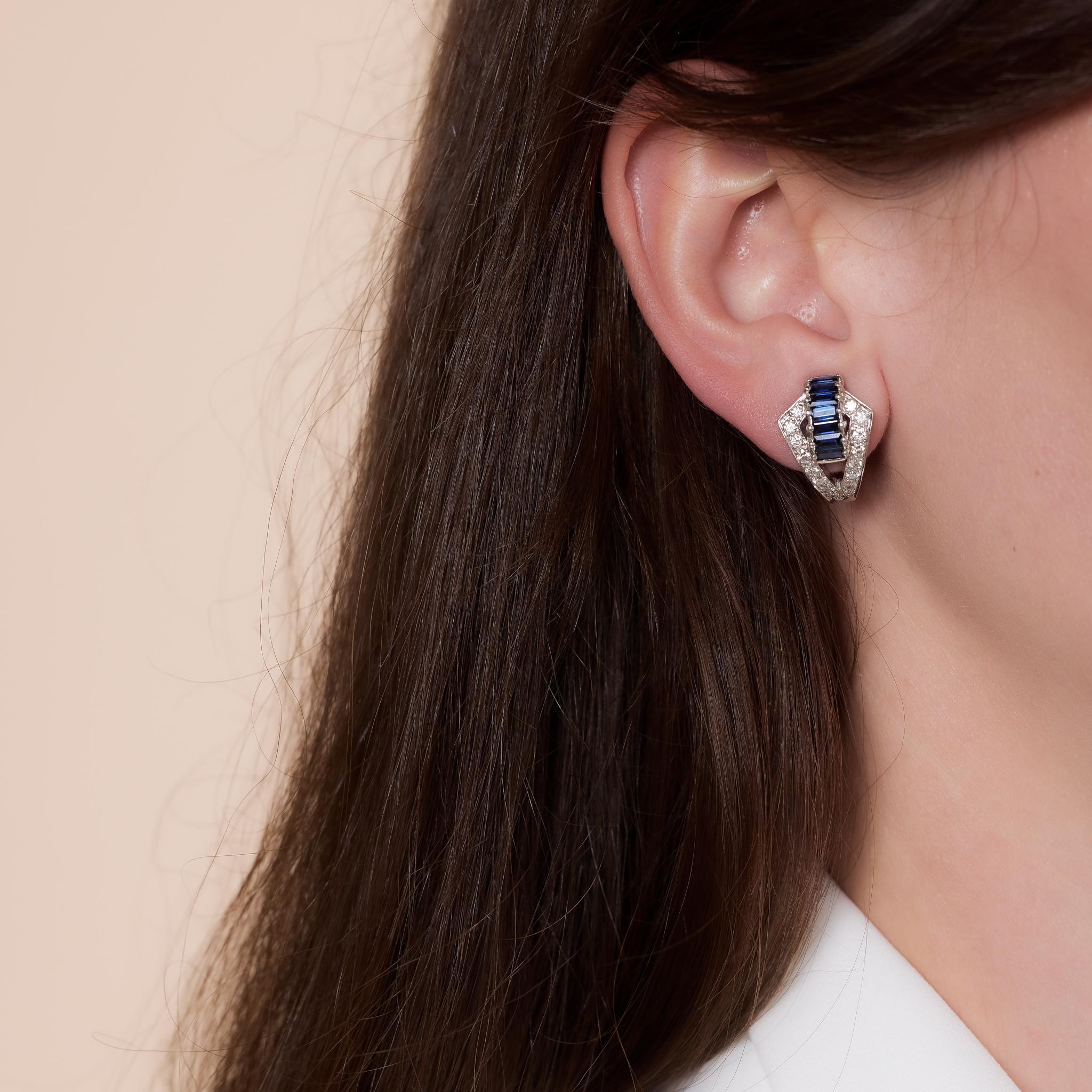 These vintage Dankner 18k white gold earrings showcase 14 baguette cut sapphires totaling 1.70 carats, accented by 32 round brilliant cut diamonds weighing .35 carats, D-E color, and VS clarity. Signed and crafted in the 1980s, they measure ¾ x ½
