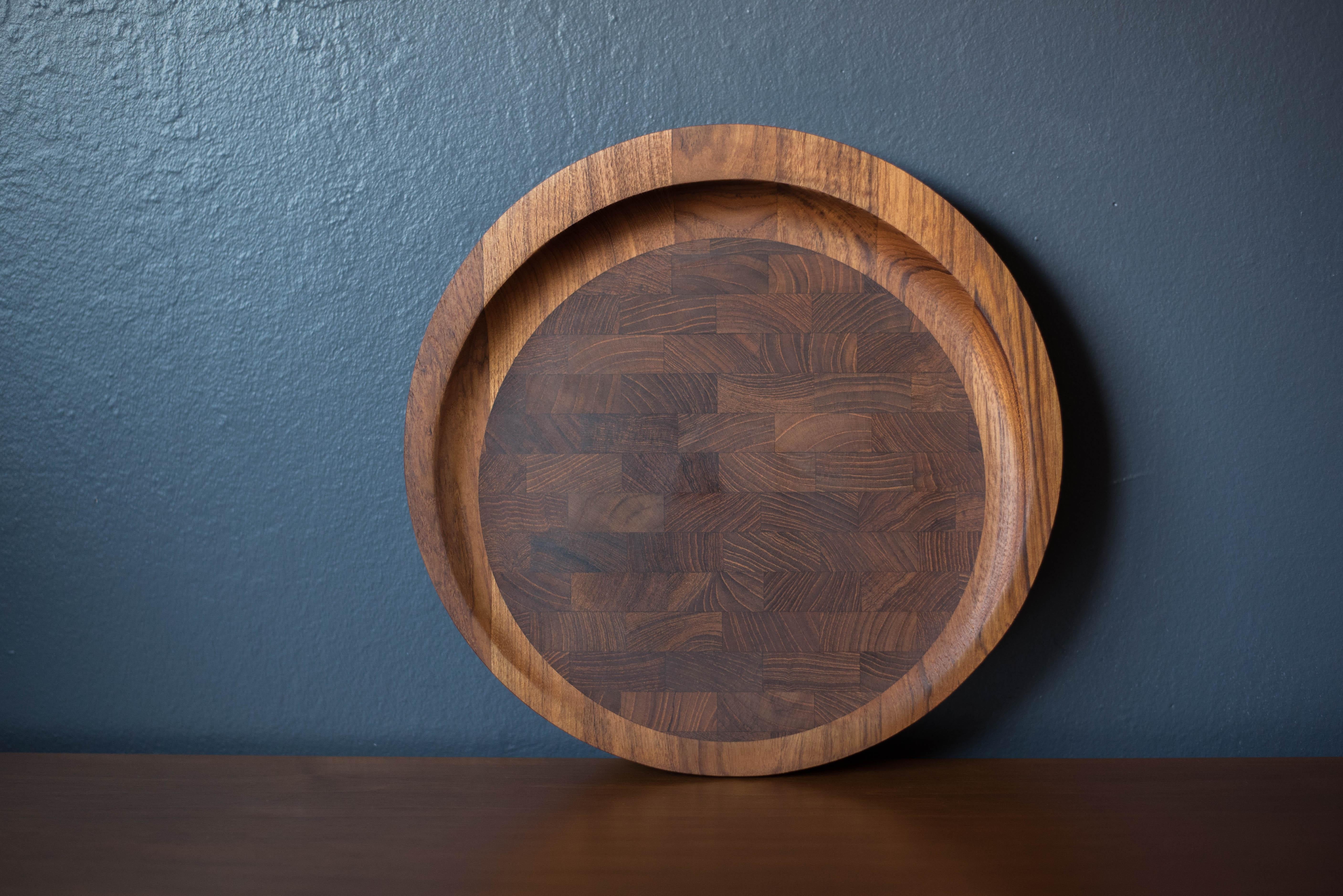 Mid-Century Modern footed cutting board tray in teak designed by Jens H. Quistgaard for Dansk, Denmark. This versatile piece is the perfect tool for carving and serving featuring a hardwood end grain center and doubles as a decorative accent tray