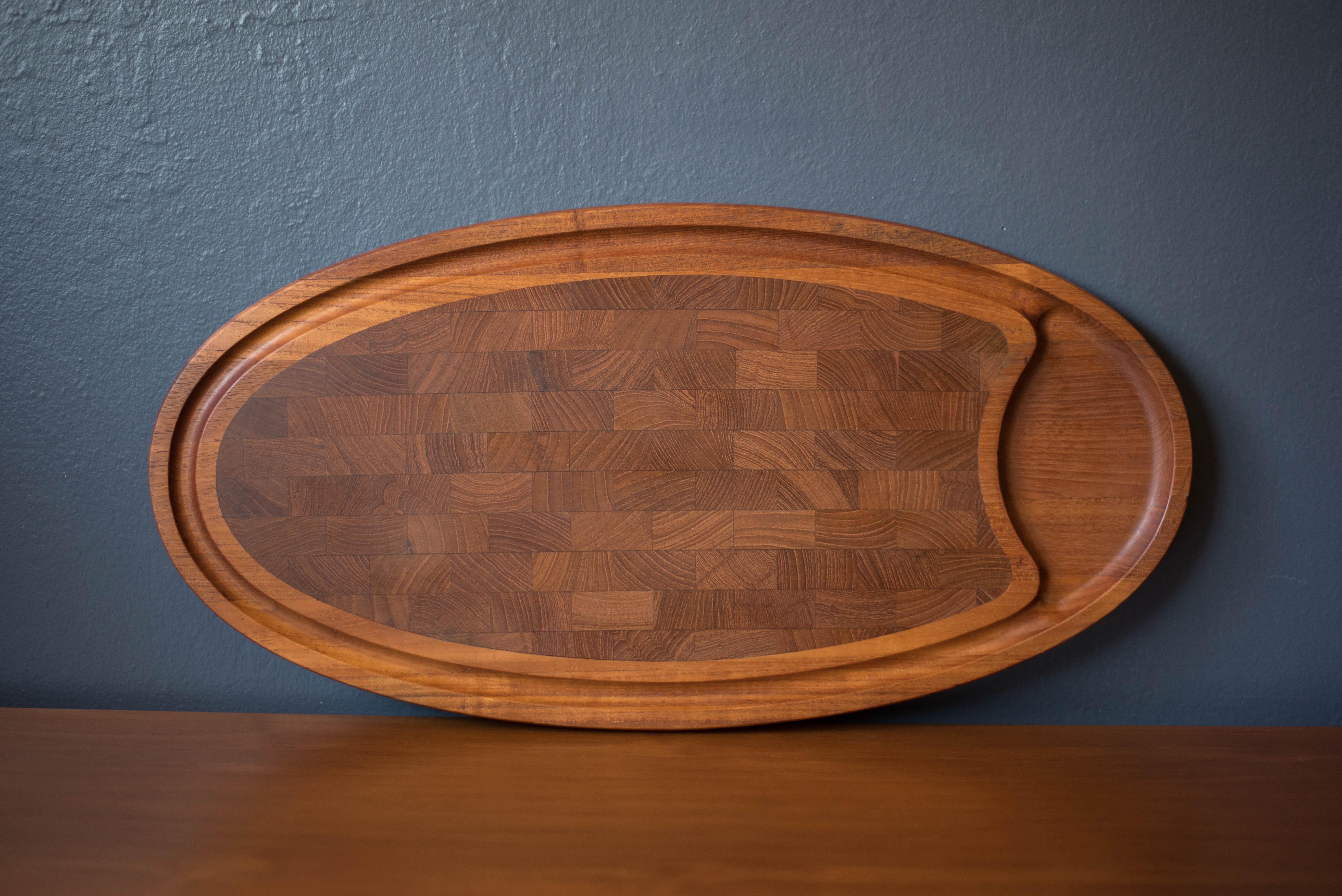 Mid-Century Modern cutting board tray in teak designed by Jens H. Quistgaard for Dansk, Denmark. This versatile piece is the perfect tool for carving and serving featuring a hardwood end grain center and doubles as a decorative accent tray when not