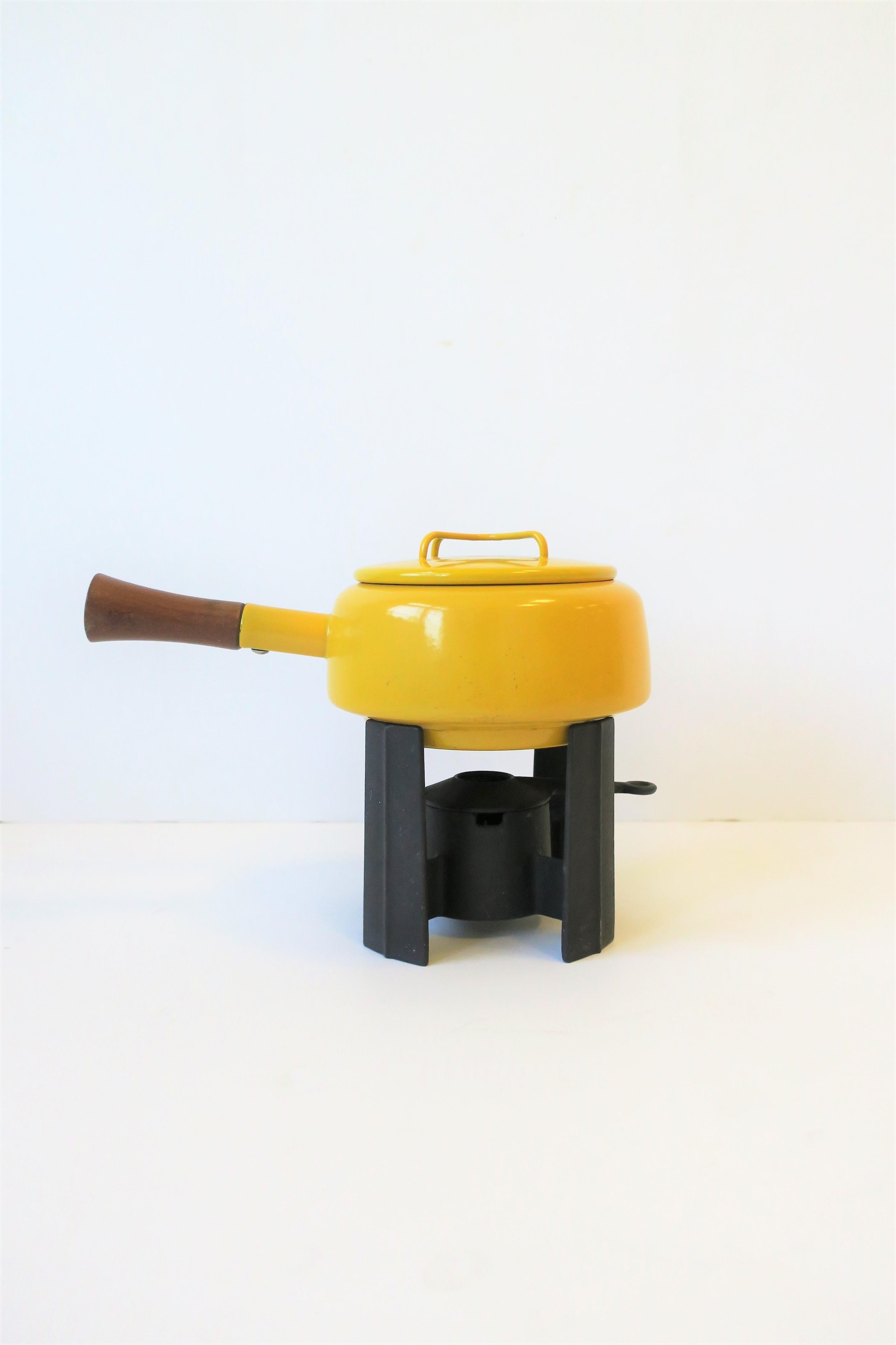 A vintage Mid-Century Modern Dansk yellow enamel fondue pot with brown wood handle and black burner, circa mid-20th century, Europe. Pot is made in France as marked, and black burner is made in Finland, as marked. (Please note, this is a correct and