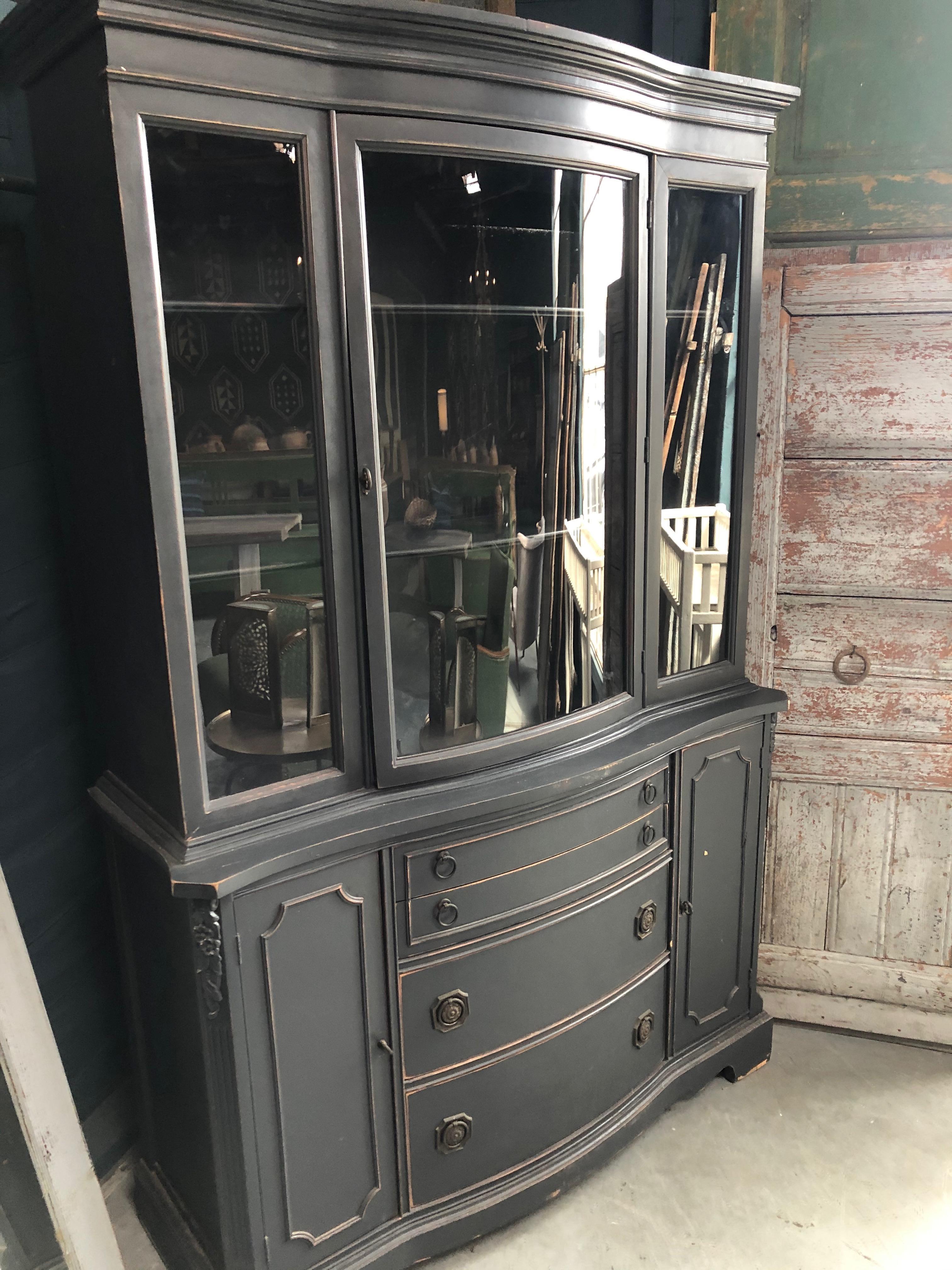 This vintage blue hutch features a sleek grey color and multiple storage options. The top part of the hutch has clear windows perfect for displaying objects while the bottom features pull out drawers and two small doors, great for more discreet