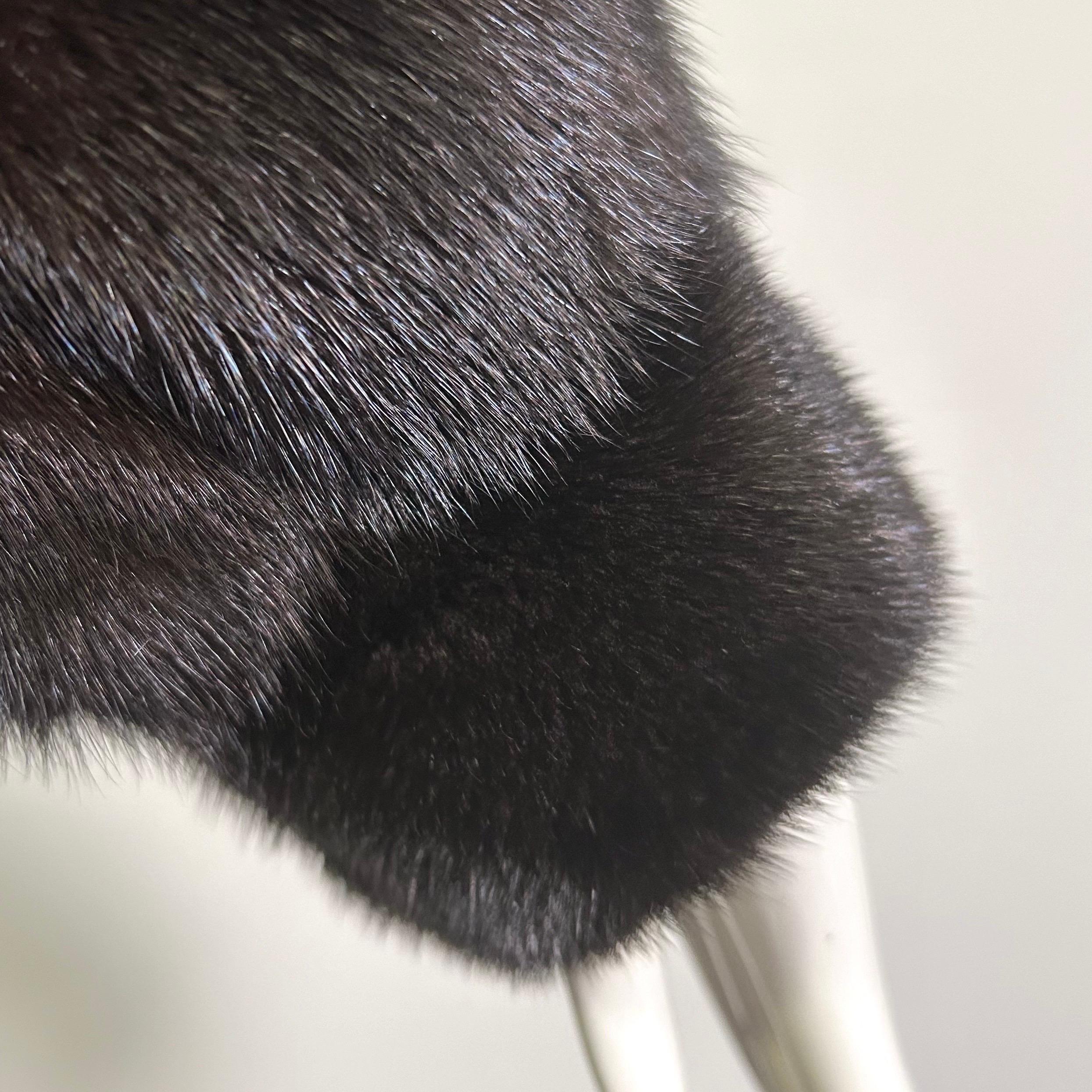 Glossy soft and supple vintage dark brown mink fur coat in a size large. Fully lined with monogram and front hook closure. Light weight structural shoulder pads. Side pockets lined in velvet. Made by Conklin Furs. The bust measures 42
