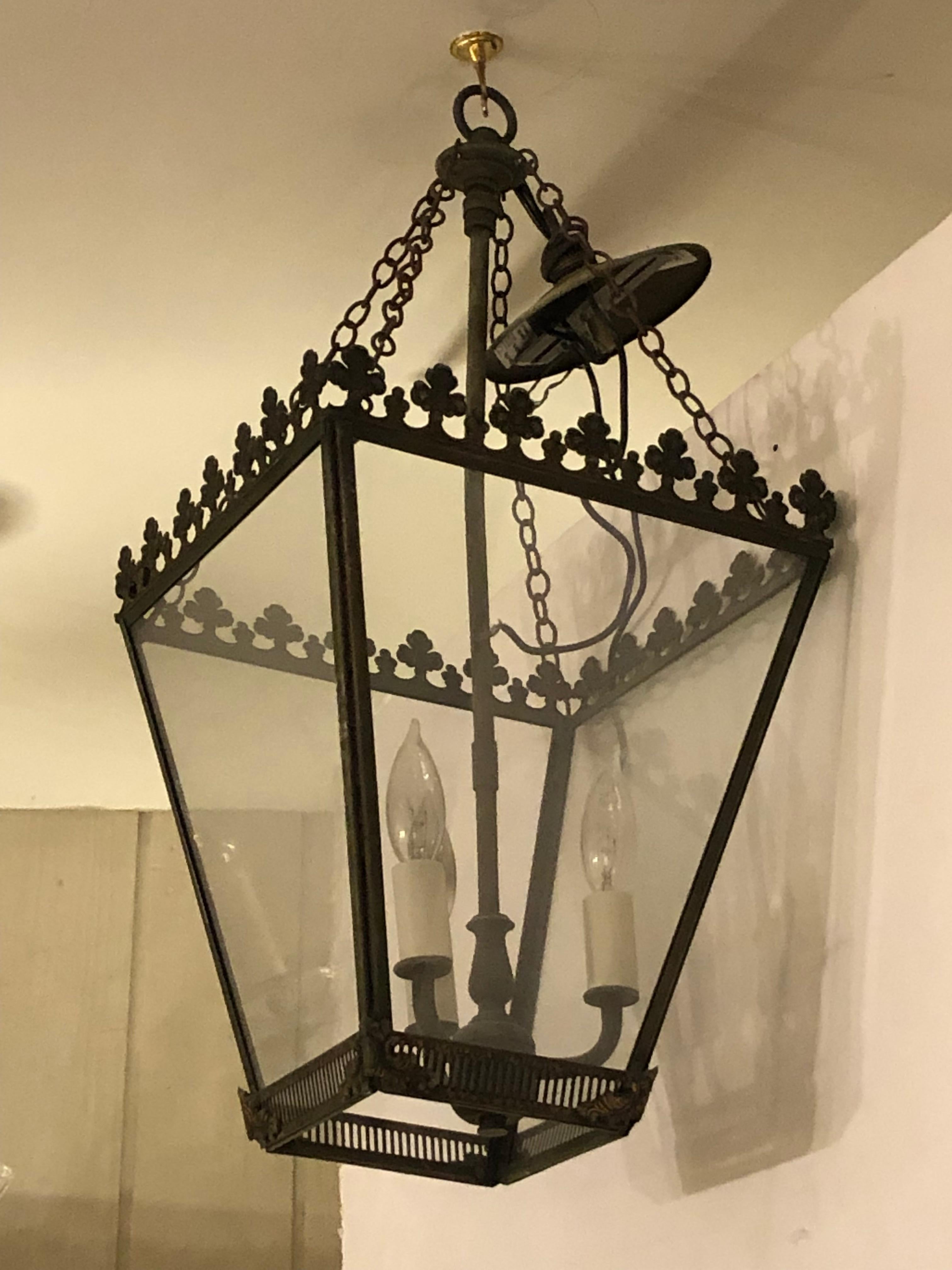 Lovely medium sized vintage very dark green tole metal and iron lantern having glass sides, 3 candle lights 40 watt each inside, and decorative clovers around the top.