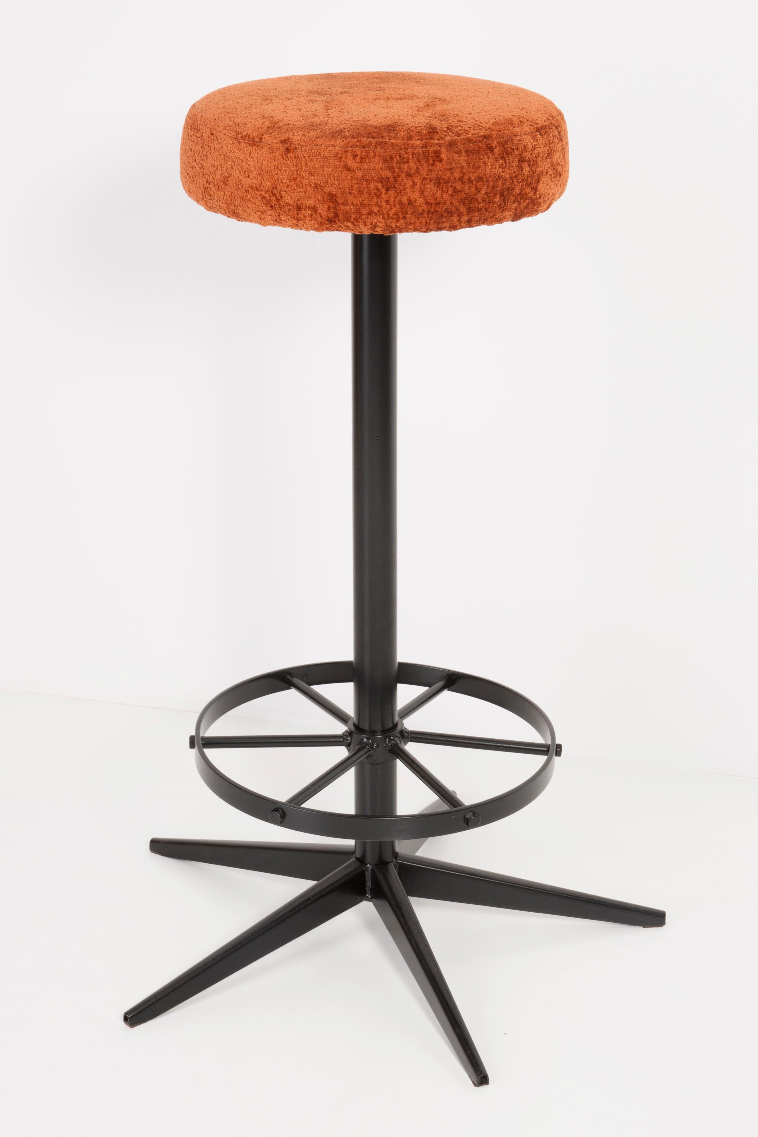 Stool from the turn of the 1960s. Produced in Germany. Beautiful, well-crafted dark orange upholstery. The stool consists of an upholstered part, a seat and steel black legs. Not regulated. The height is constant.