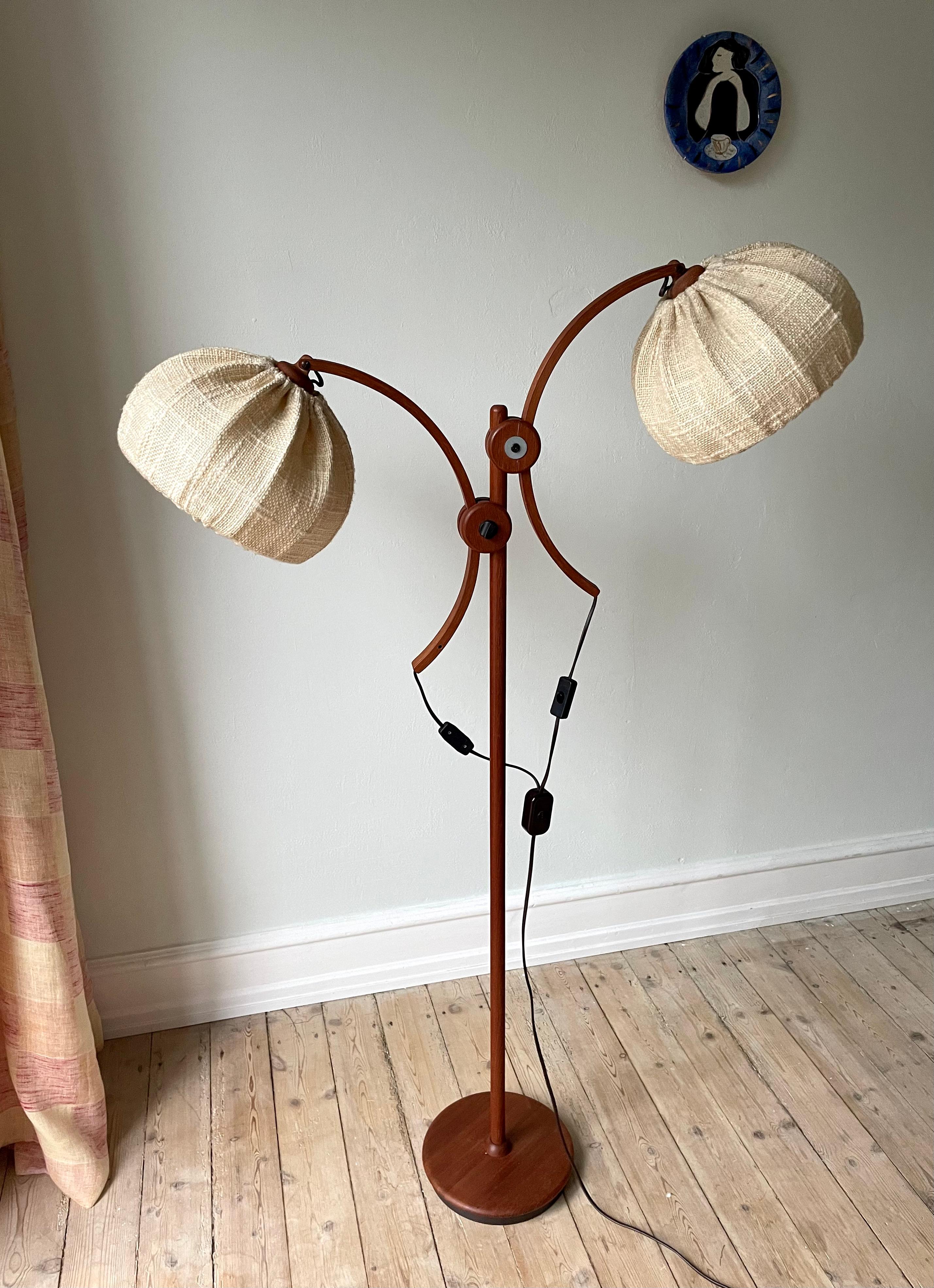 Organic midcentury modern wooden floor lamp with two semi circle adjustable shades in golden sand colored thick textile. Manufactured in the 1960s by Temde Leuchten (attr.). Two semi circle arms of bent wood that are adjustable in every direction on