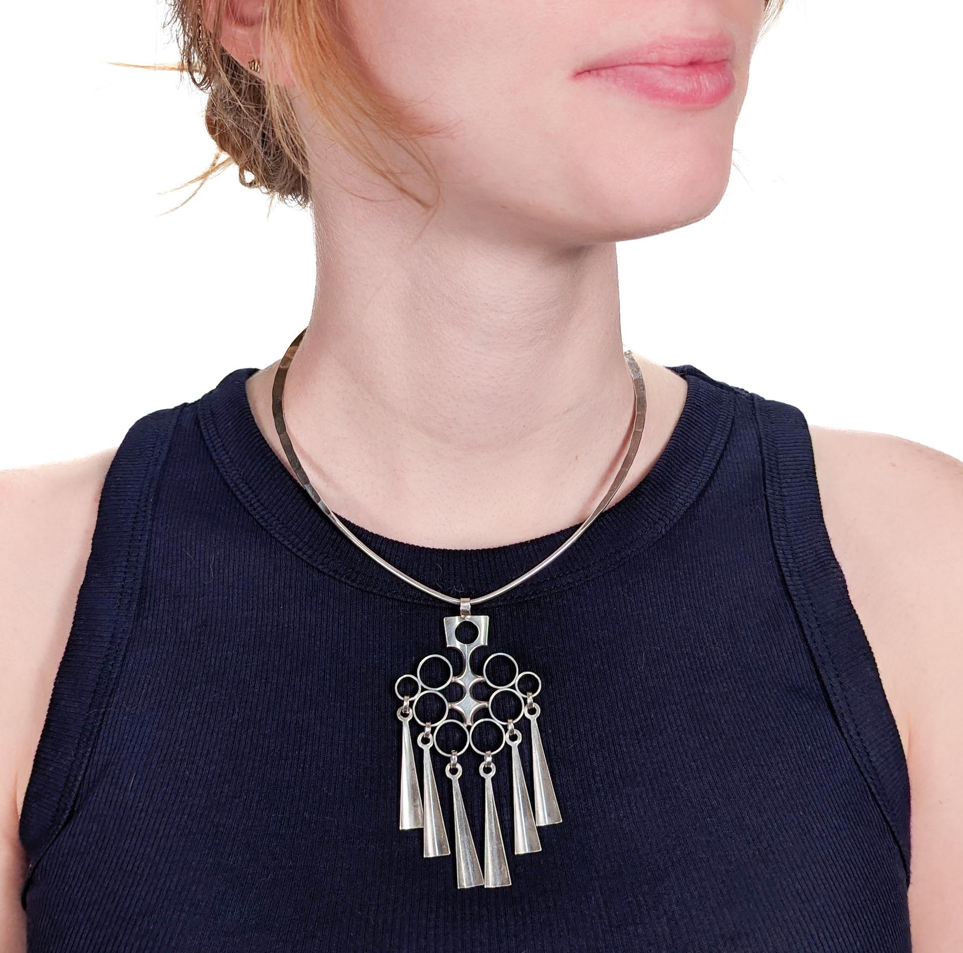A fine Mid-Century Modern necklace or neckpiece.

By David Andersen.

In sterling silver. 

Comprised of neckpiece and a kinetic pendant.

Marked to the reverse of the pendant for 925S / David-Anderson / Norway / Sterling, and marked to the collar