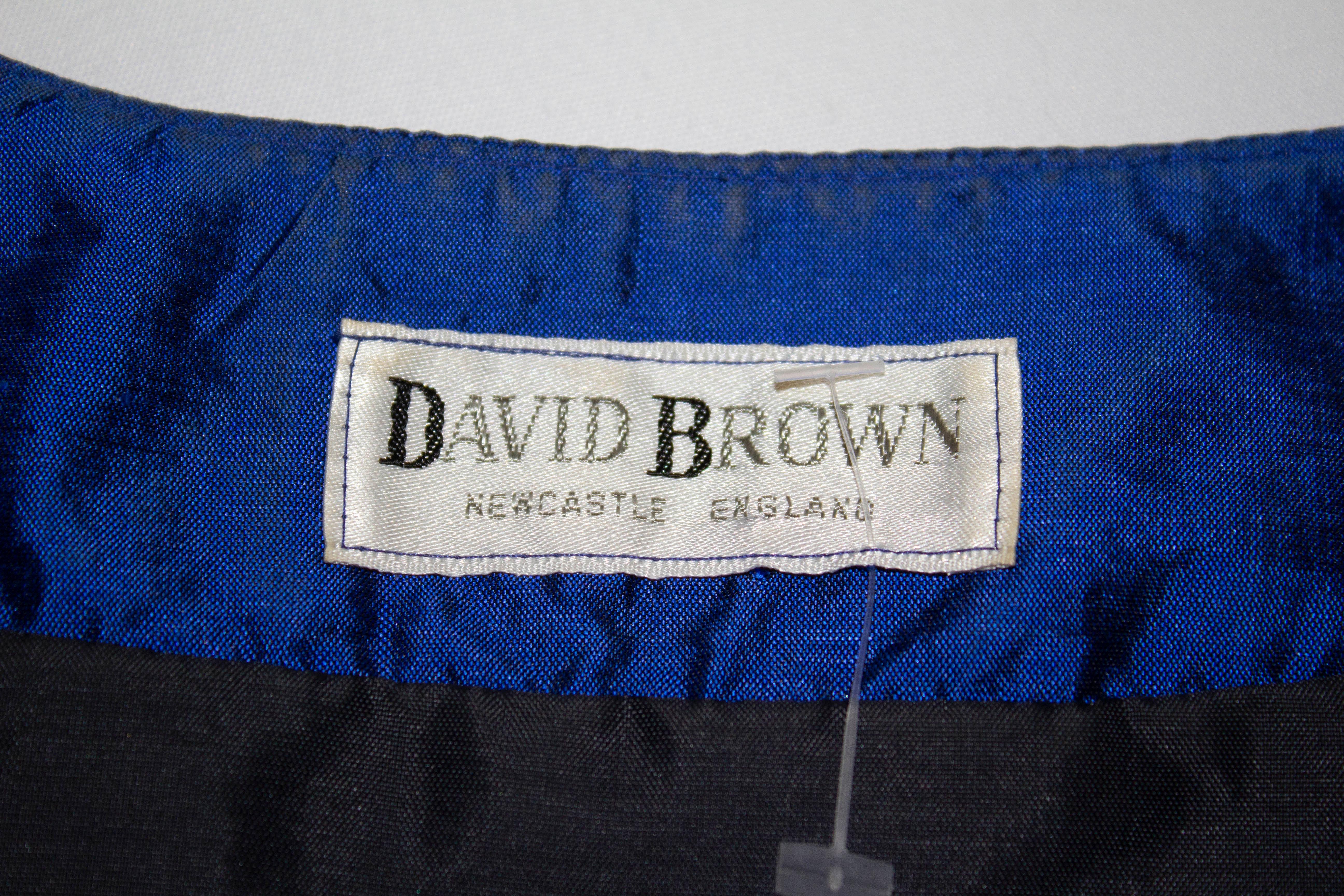 Un divertente abito da sera vintage di David Brown.  L'abito è in un colore reale  In seta blu, la giacca ha uno scollo a cuore con apertura frontale a bottoni e maniche a sbuffo.  La gonna ha un'arricciatura che parte dall'attaccatura dei fianchi e