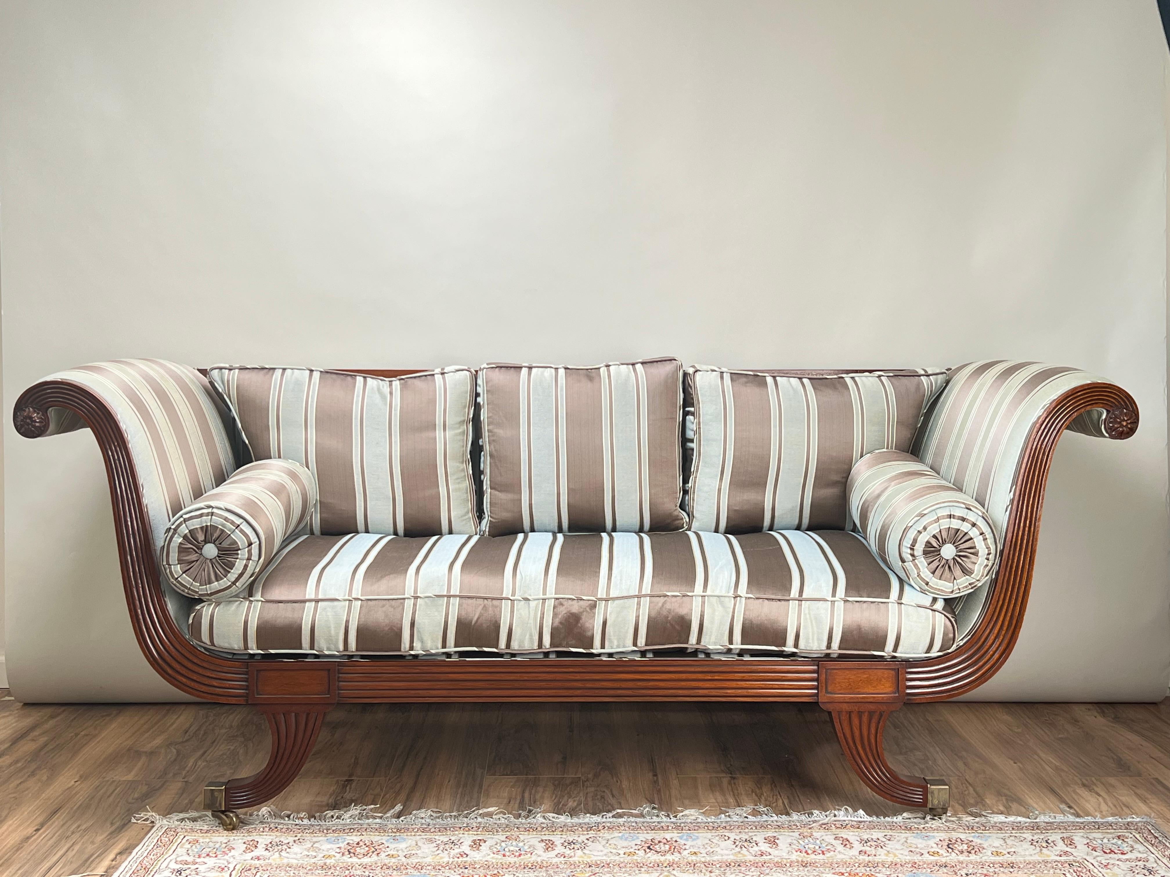 Questo divano vintage in stile Regency in mogano di David Salmon Furnishers incarna perfettamente l'elegante semplicità del design Regency con la sua struttura in mogano finemente lavorata e la sua lussuosa tappezzeria. I bracci ampi e arcuati e le