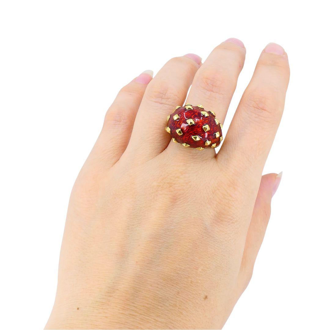 Cette bague vintage David Webb est réalisée en or jaune 18 carats avec un dôme en émail guilloché rouge accentué par des clous en or en relief. Le design audacieux met en valeur le style distinctif de Webb, combinant un émail vibrant avec des