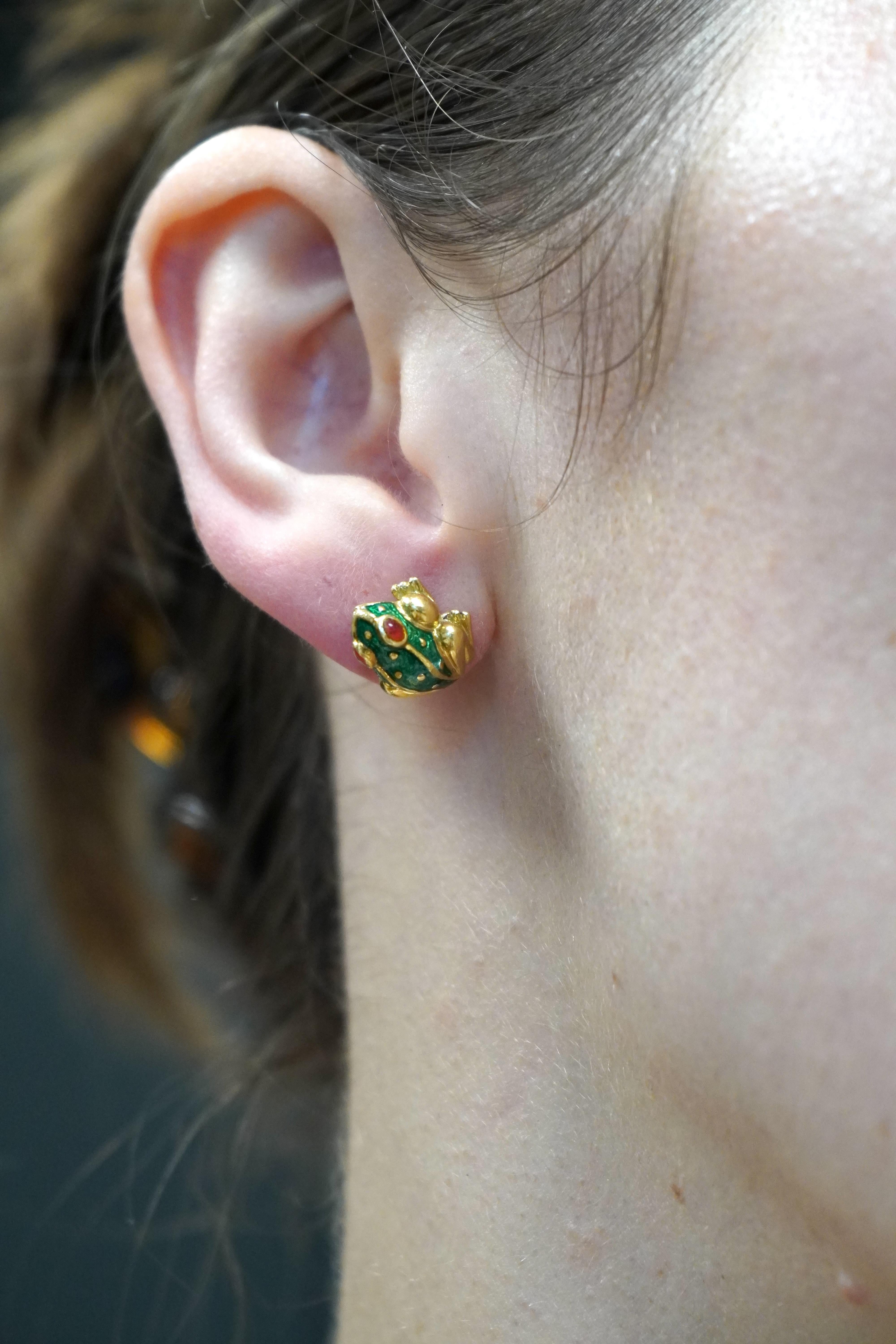 This pair of David Webb frog stud earrings is crafted in 18K gold with vibrant enamel detailing. Weighing 8.7 grams, each earring measures approximately 1/2 inch by 1/2 inch and is designed for pierced ears. The design features a three-dimensional