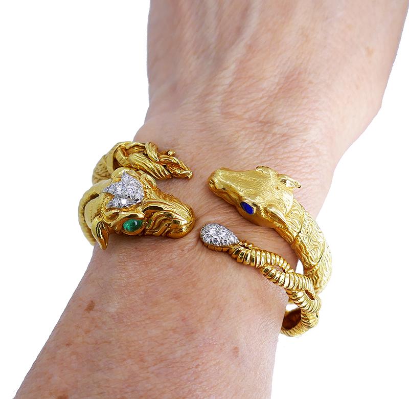 A remarkable pair of gold bracelets by David Webb.
The ram, a symbol of strength and resilience, is detailed with precision and artistry. The forehead and tail are adorned with round cut diamonds set in platinum. The cabochon emeralds add green