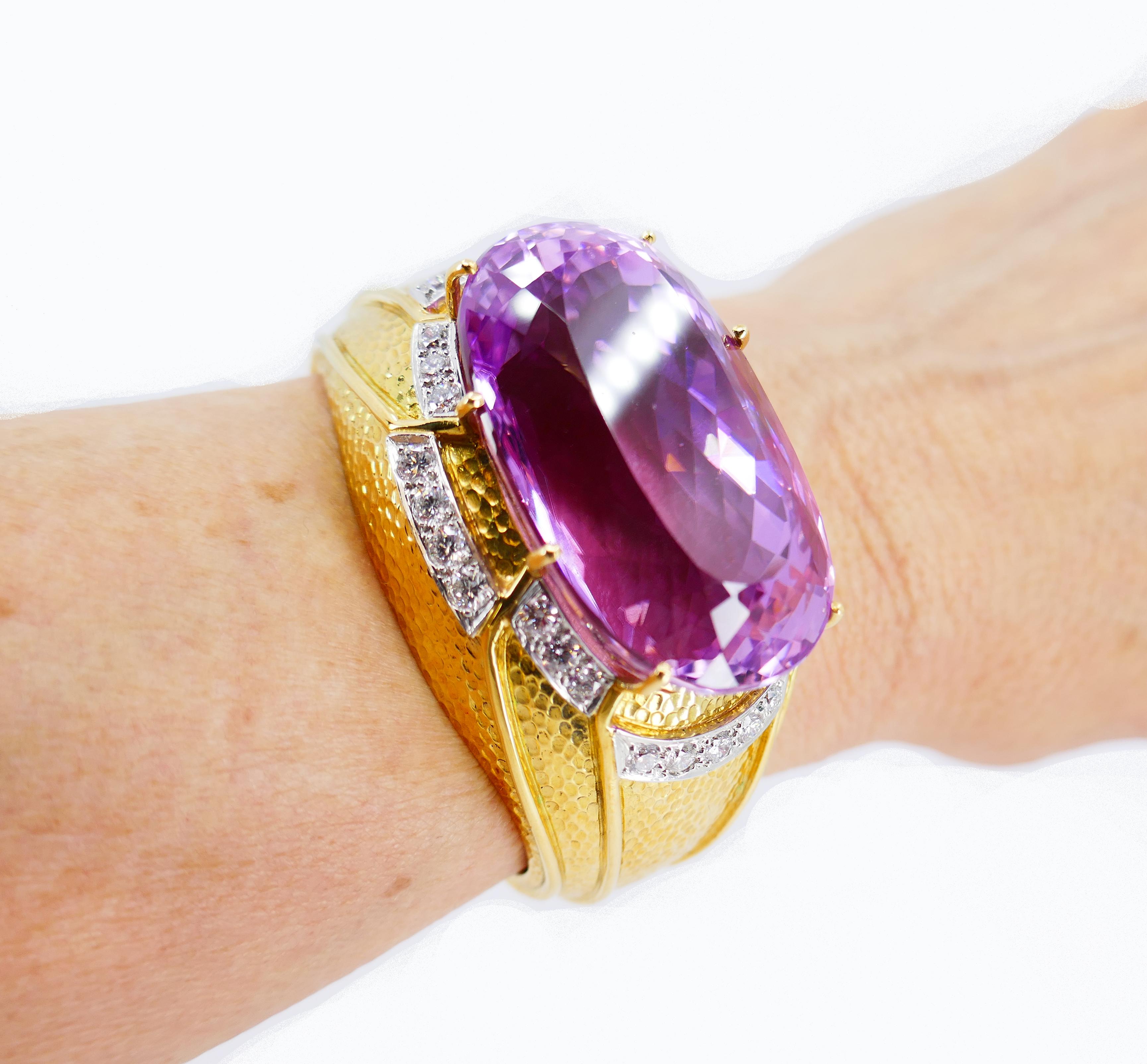 A stunning gold bracelet featuring kunzite and diamond, made by David Webb.
This impressive kunzite bracelet is made of beautifully hammered 18k yellow gold. The kunzite is staged in the center and framed with diamonds set in platinum. Four gold