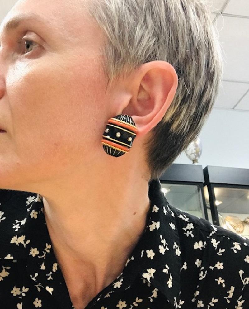 An impressive pair of David Webb's earrings, made in 18k gold, features diamond, black, and red enamel.
These barrel-shaped earrings carry the best of Webb's features: a substantial size and daring attitude. Glossy black enamel is underlined with
