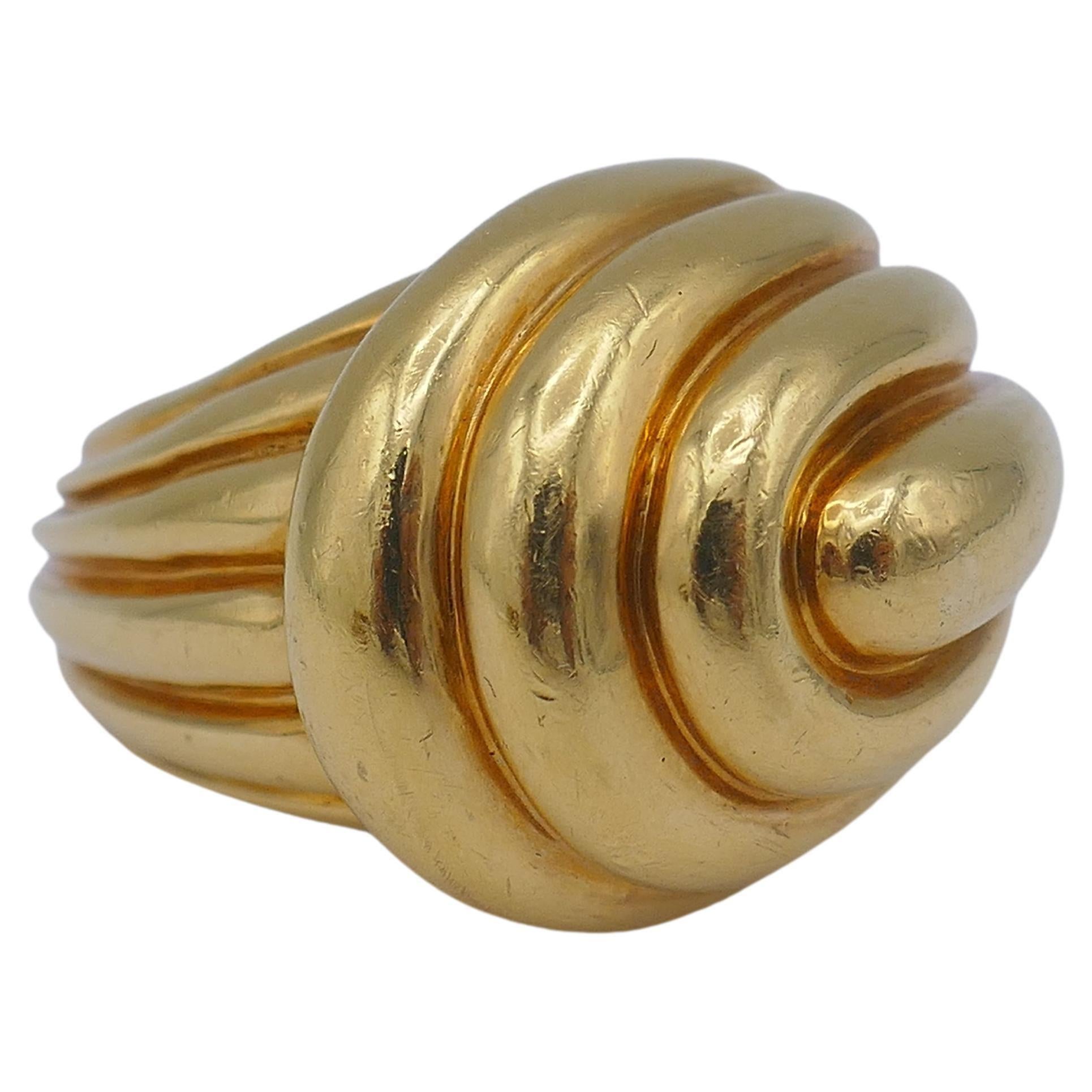 A classic David Webb 18k gold ring. 
The ring is designed as a ribbed gold swirl wrapped around a finger. The gold looks soft, and with an amazing vintage hue has depth and silky texture. 
The ring is chunky yet fluid, and its shape is equally