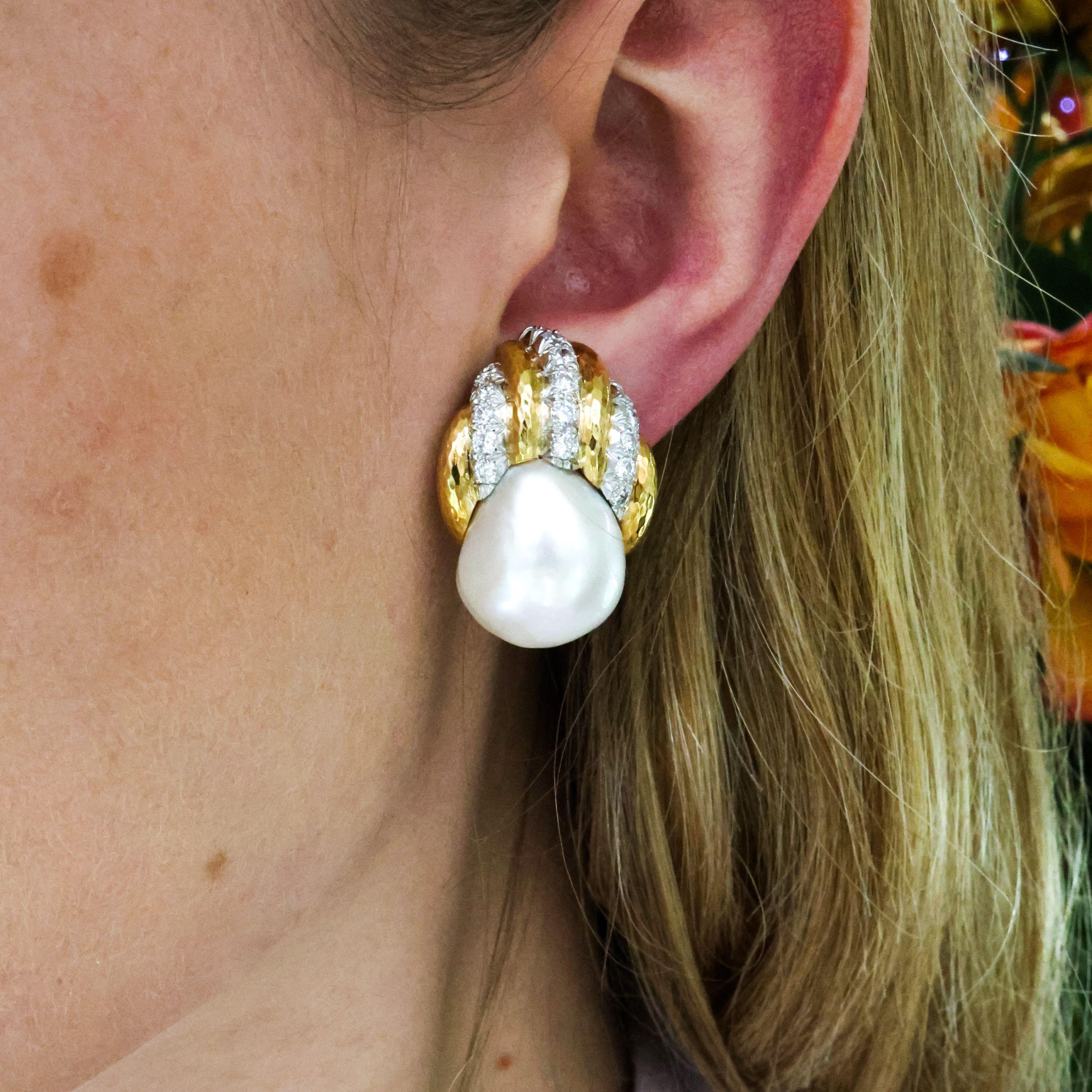 A pair of vintage earrings by David Webb, the free-form white pearls housed in textured yellow gold segments, with three rows of brilliant cut diamonds set into platinum, weighing an estimated total of 1.00 carat, with hinged clip fittings to the