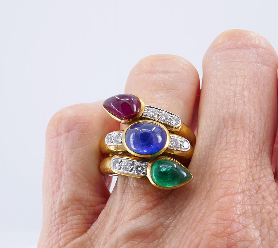           A great vintage ring by David Webb made of 18 karat yellow gold, featuring four most important gemstones - diamond, ruby, emerald and sapphire.
         The ring has wrap-around stylized snake design with the cabochon cut bezel set