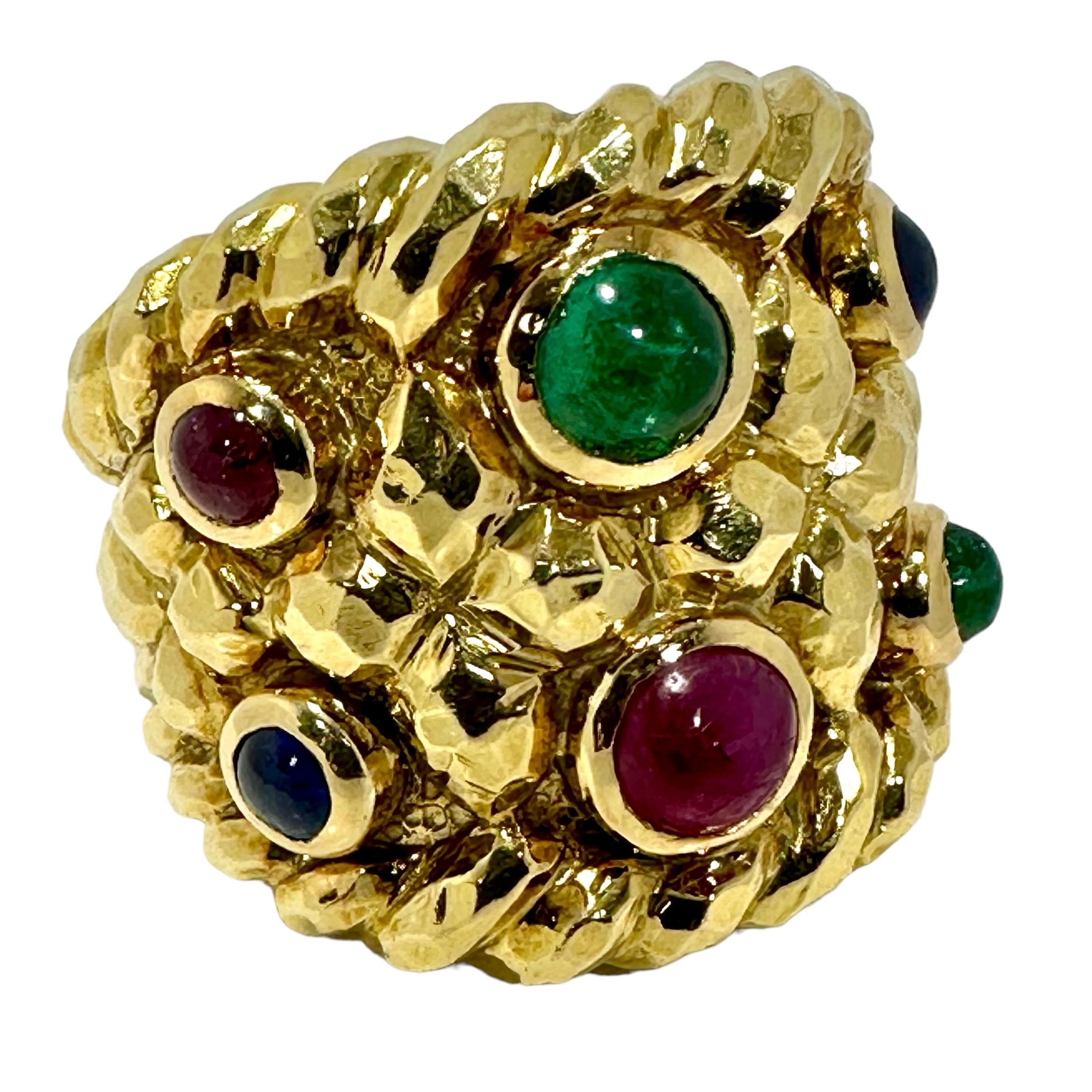 This massive and unique David Webb creation is truly impressive to behold. A 25mm wide design area is comprised of a total of six ruby, sapphire, and emerald cabochons, bezel set in a field of chunky and very dimensional gold nuggets, flanked on