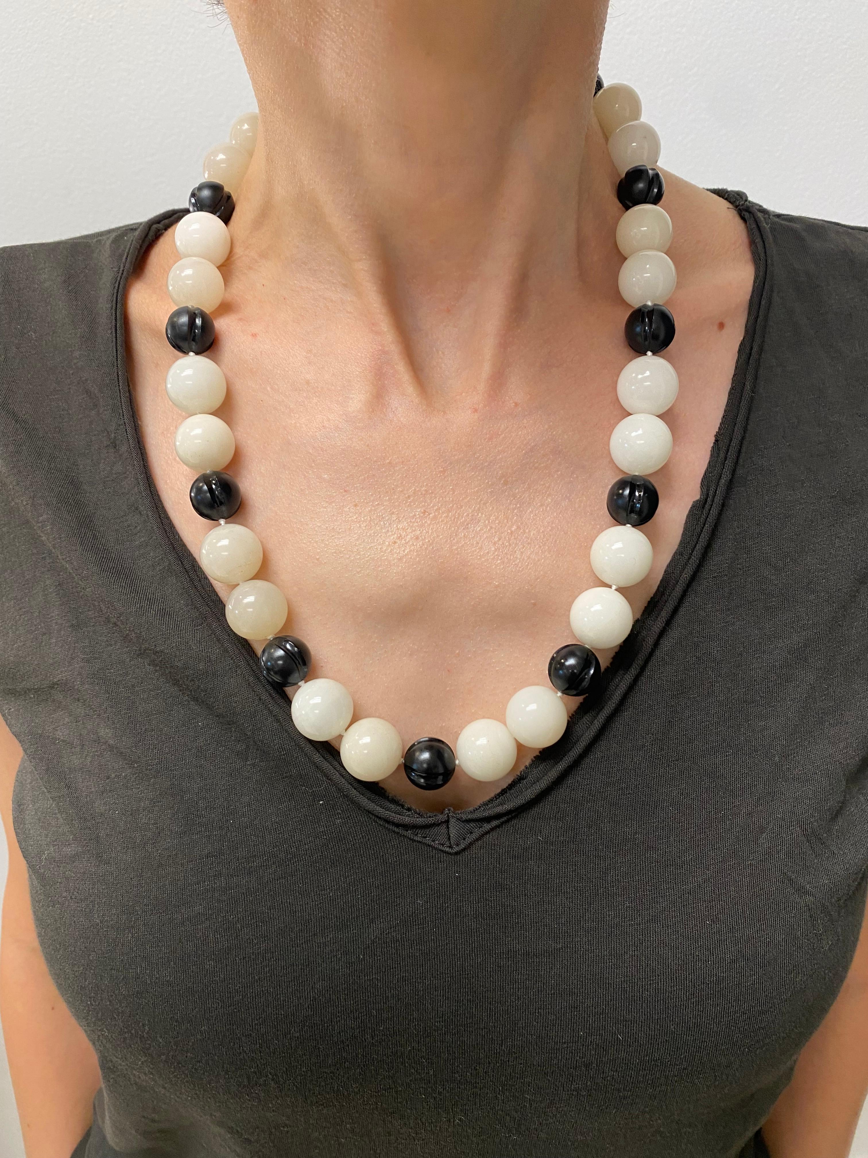 Product details:

The necklace is designed by David Webb, it is made out of 18 karat yellow gold, carved onyx and quartz, featuring box clasp closure. The smaller bead measures 9/16