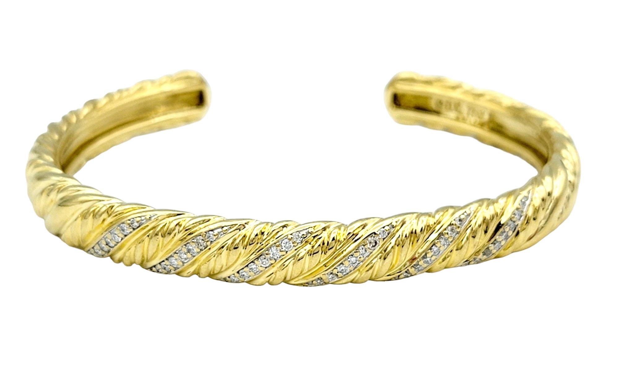 Dieser atemberaubende David Yurman Diamant-Armreif aus strahlendem 18-karätigem Gelbgold ist ein beeindruckendes Zeugnis für den unverwechselbaren Stil und die exquisite Handwerkskunst der Marke. Mit seinem gedrehten Design strahlt das Armband einen