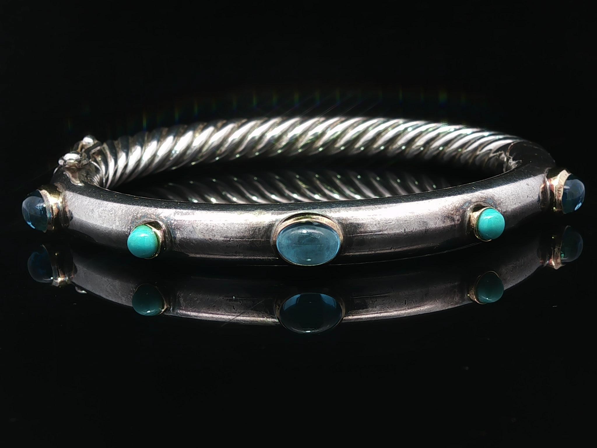 --Stone(s):--
(3) Natural Genuine Blue Topaz - Oval Cabochon Cut - Bezel Set - Blue Color - 7x4.8mm each (approx.)
(2) Natural Genuine Turquoise - Round Cabochon Cut - Bezel Set - Blue Color - 3.6mm each (approx.)

Material: Solid Sterling Silver