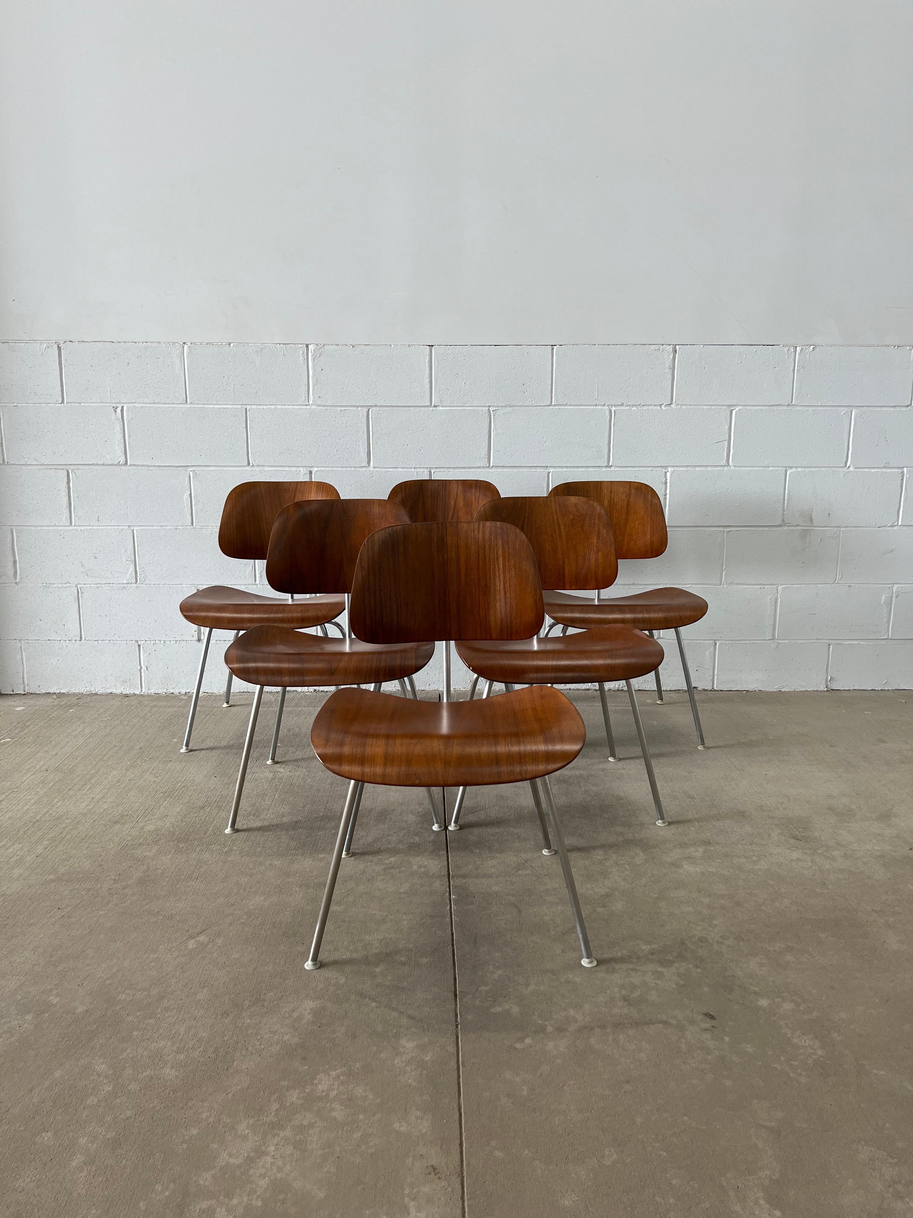 The chair that started it all. Masters of molded plywood, the Eames adapted their dining chair wood to be fitted with a metal base and thus the dining chair metal was born. 

This set of walnuts chairs spans a couple editions as evidenced by the