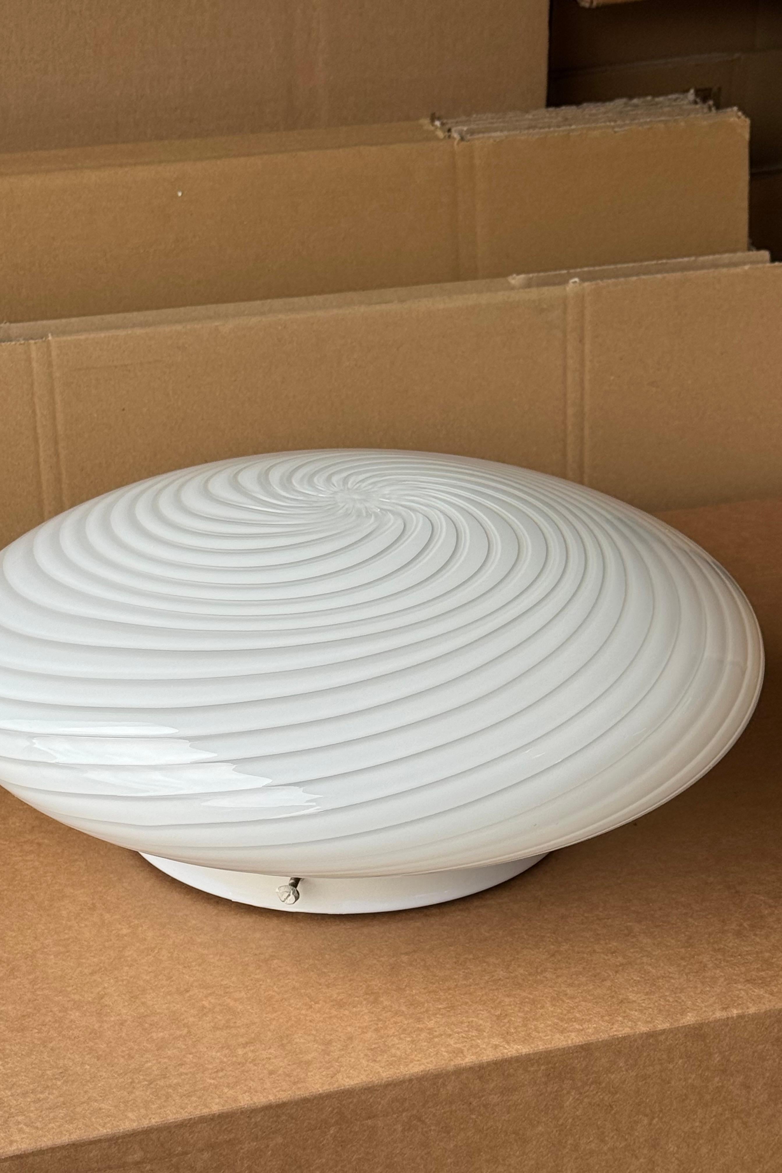 Lampada da soffitto/parete plafond vintage De Majo Murano. Vetro opalino bianco soffiato a bocca, con volute e base bianca. Presa E27. Realizzato a mano in Italia, anni '70. Firmato. 
D:38 cm H:14 cm
