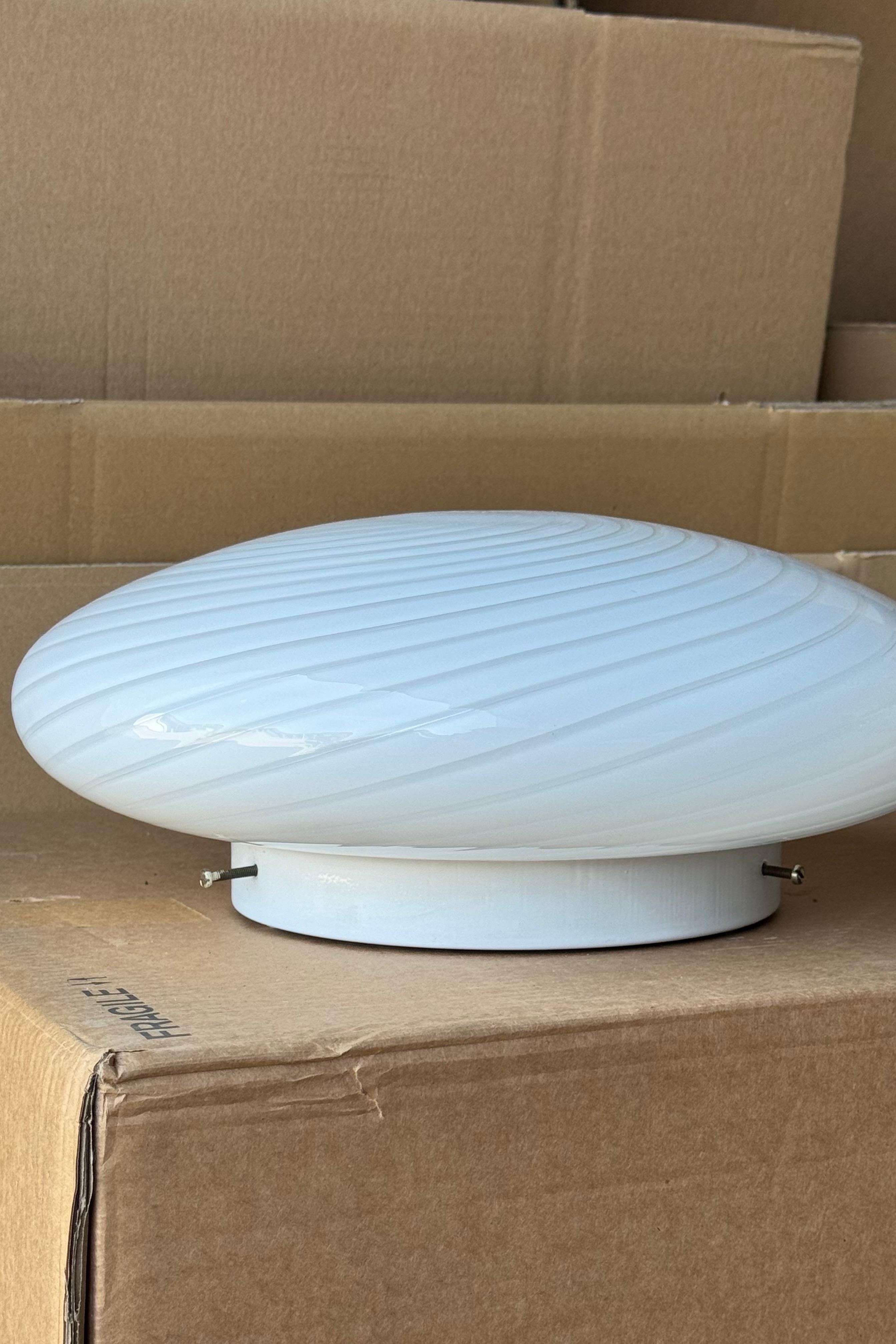 Lampada da soffitto/parete plafond vintage De Majo Murano. Vetro opalino bianco soffiato a bocca, con volute e base bianca. Presa E27. Realizzato a mano in Italia, anni '70. Firmato. 
D:38 cm H:15 cm
