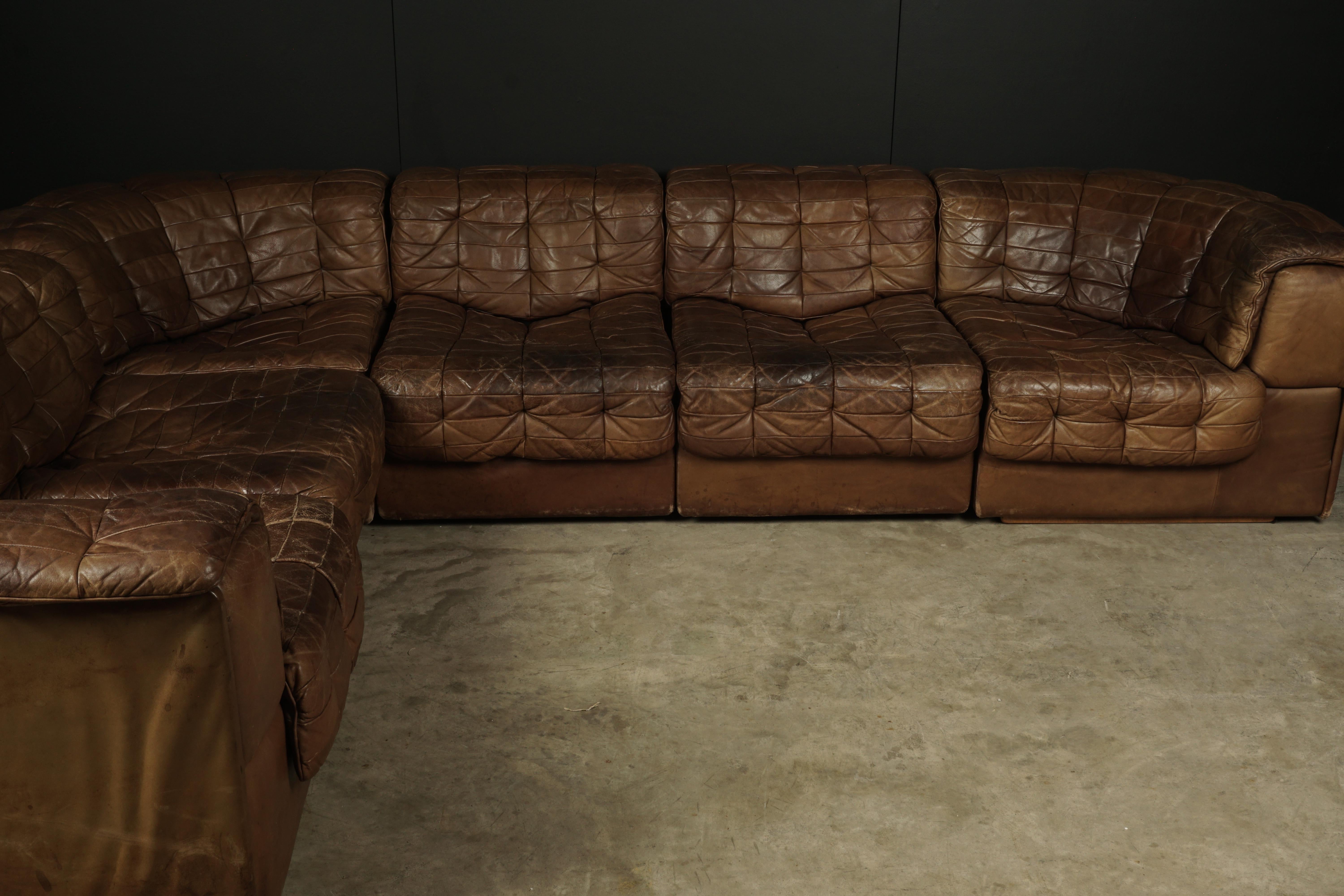 Rare vintage De Sede DS 11 patchwork leather sofa from Switzerland, circa 1970. Original cognac leather upholstery with great wear and patina. Six modular pieces. Each module is 61cm high and 64cm width, seating height is 36cm corner module is H