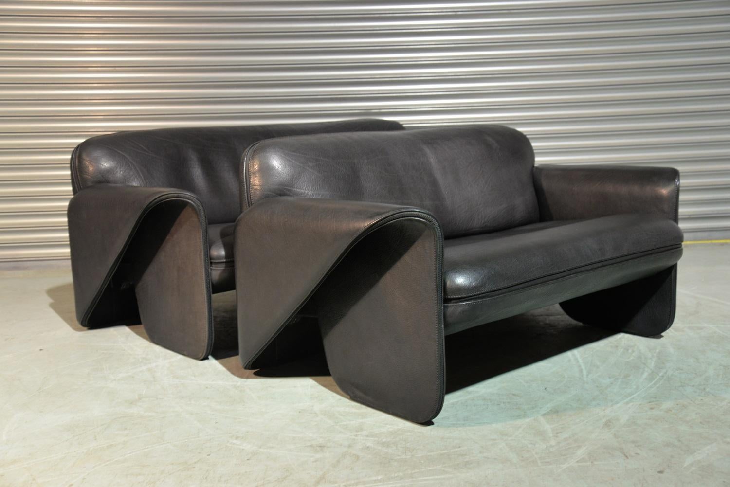 We are delighted to bring to you an ultra rare pair of vintage De Sede DS 125 sofas designed by Gerd Lange in 1978. These sculptural pieces are upholstered in thick 3mm-5mm black leather with a decorative zipper seam. These pieces are in excellent
