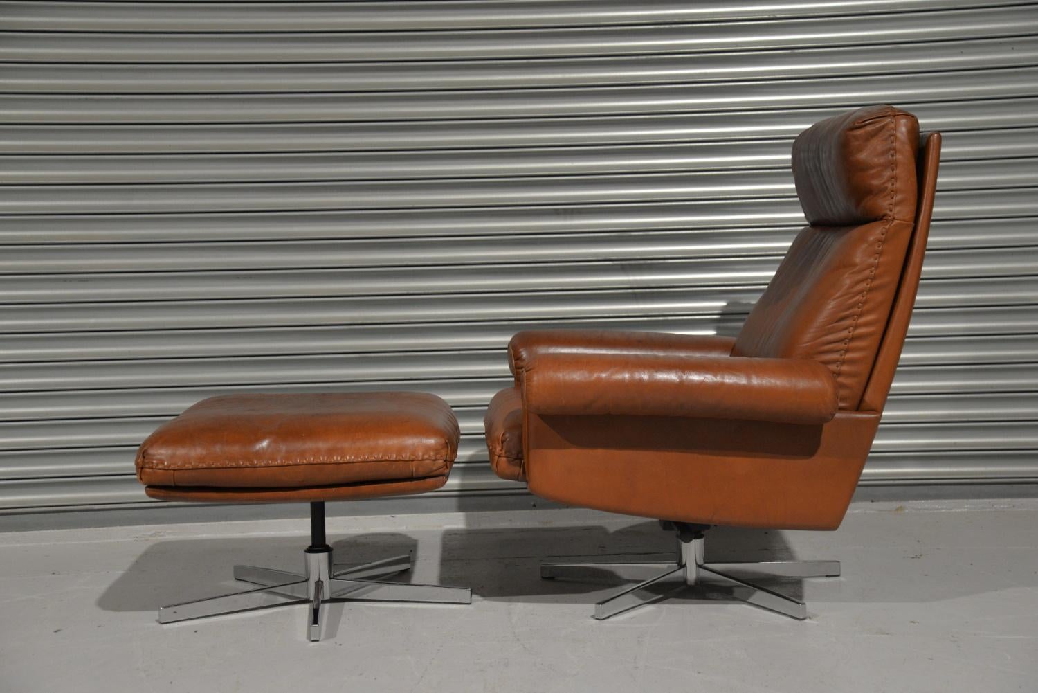 We are delighted to bring to you a highly desirable and rarely available vintage 1970s De Sede DS 31 high back swivel reclining leather armchair with ottoman. Hand built in the 1970s by De Sede craftsman in Switzerland. The swivel leather armchair