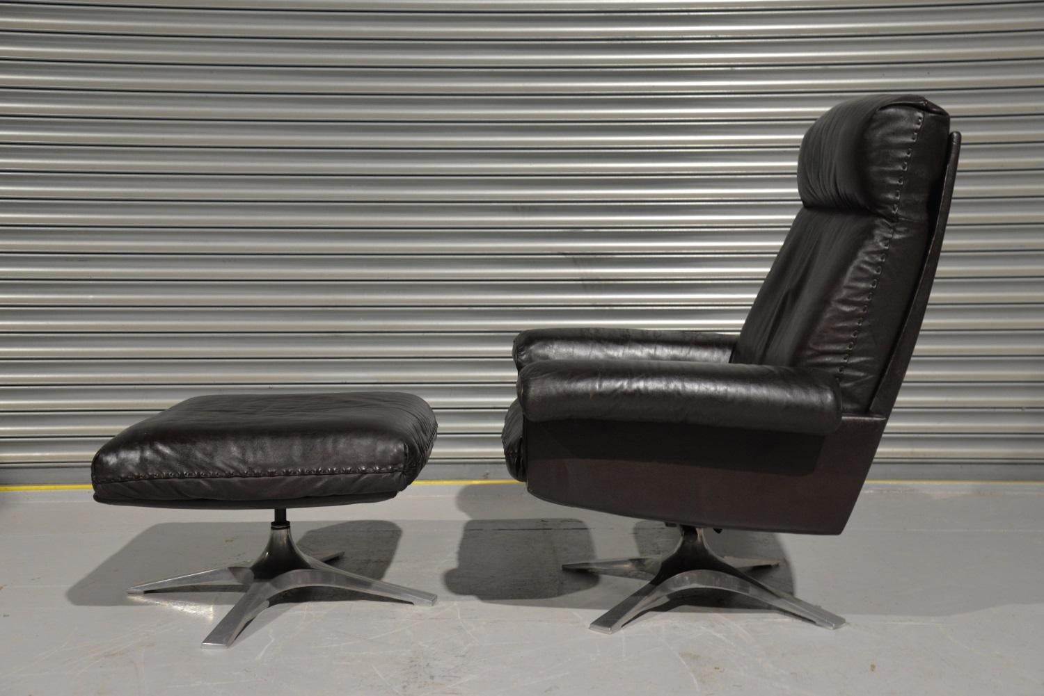 We are delighted to bring to you a highly desirable and rarely available vintage 1970s De Sede DS 31 high back swivel leather armchair with ottoman. Hand built in the 1970s by De Sede craftsman in Switzerland. The swivel leather armchair stands on a