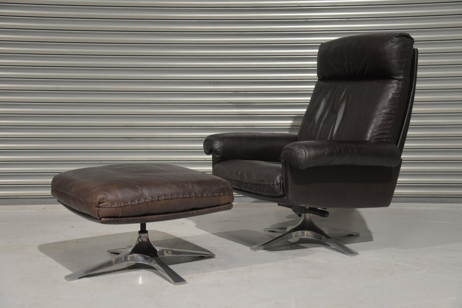 We are delighted to bring to you a highly desirable and rarely available vintage 1970s De Sede DS 31 high back swivel leather armchair with ottoman. Hand built in the 1970s by De Sede craftsman in Switzerland. The swivel leather armchair stands on a