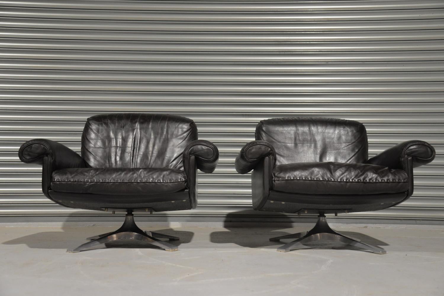 We are delighted to bring to you a pair of highly desirable retro De Sede DS-31 swivel lounge armchairs in beautiful soft dark brown leather with whipstitch edge detail standing on brushed aluminium swivel bases. Hand built in the early 1970s by De