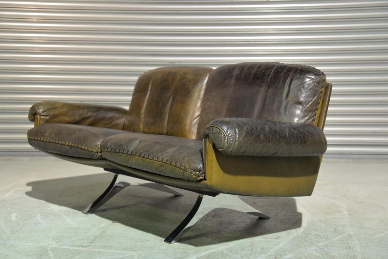 We are delighted to bring to you a vintage 1970s De Sede DS 31 two-seat sofa or loveseat in olive/brown aniline leather with superb whipstitch edge detail. Hand built circa 1970s by De Sede craftsman in Switzerland, the sofa or loveseat sits on