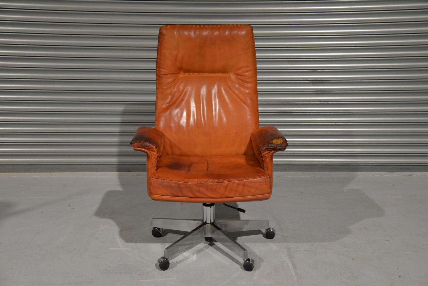 We are delighted to bring to you an extremely rare vintage De Sede DS 35 Executive armchair on casters. Hand built to incredibly high standards by De Sede craftsman in Switzerland. The iconic swivel armchair is upholstered in stunning tan aniline