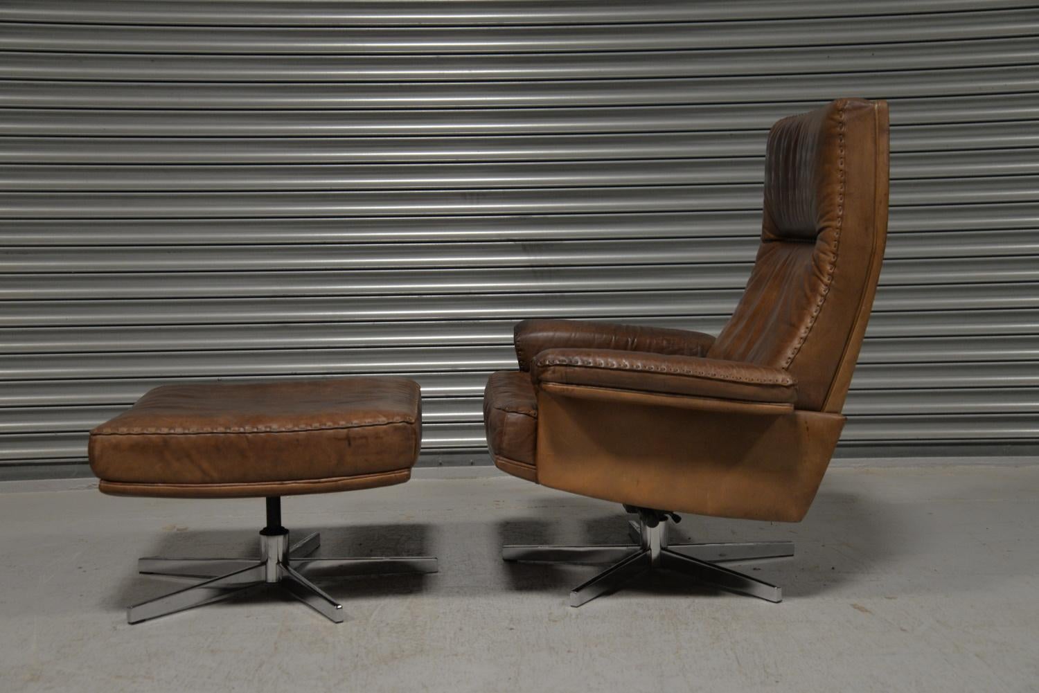 We are delighted to bring to you a highly desirable and rarely available vintage 1970s De Sede DS 35 high back swivel armchair with ottoman. Hand built in the 1970s by De Sede craftsman in Switzerland. The swivel armchair and ottoman Stand on a
