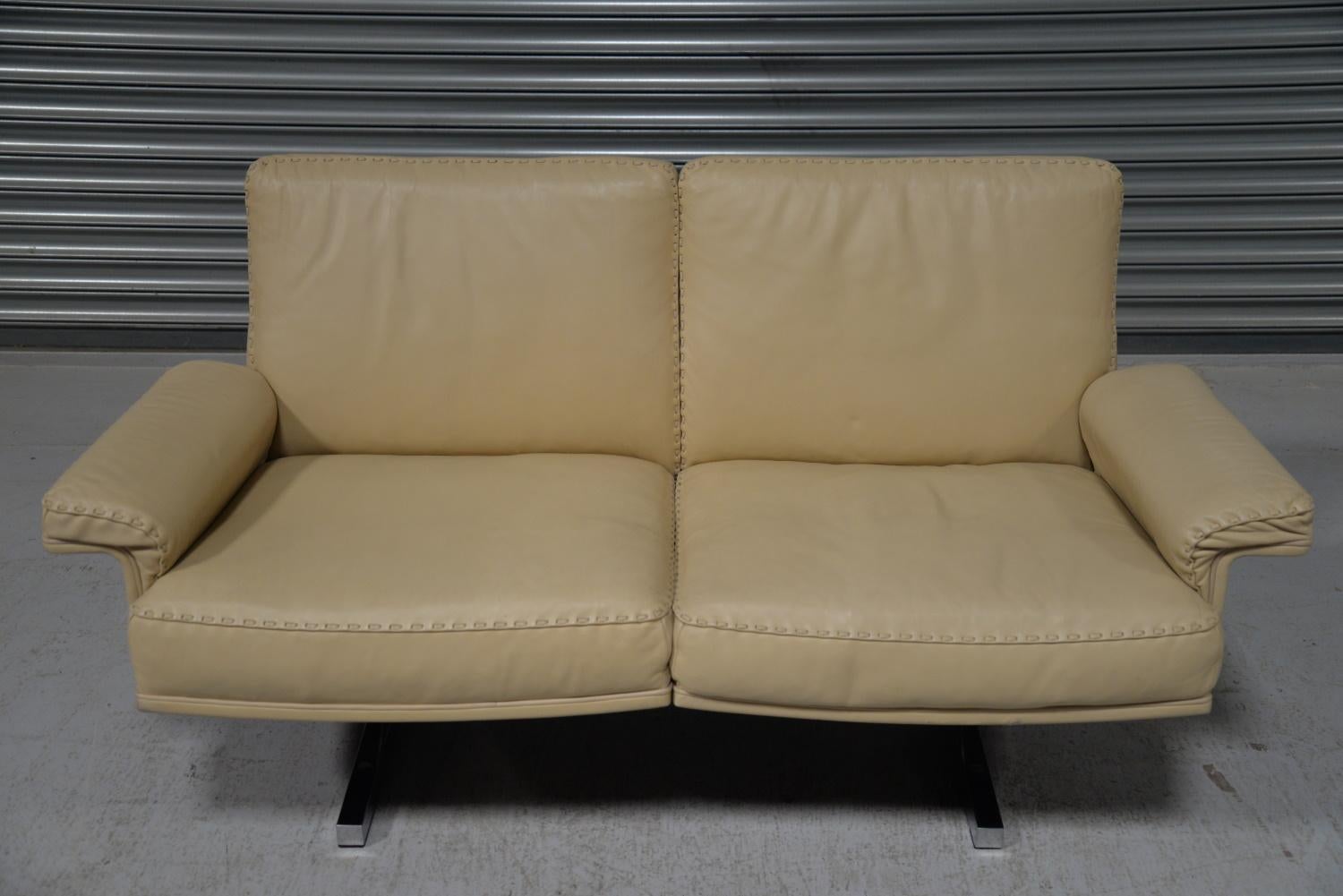We are delighted to bring to you a rarely available and highly desirable De Sede DS 35 two-seat sofa or loveseat in beautiful soft cream aniline leather with superb whipstitch edge detail. Hand built in the early 1970s by De Sede craftsman from