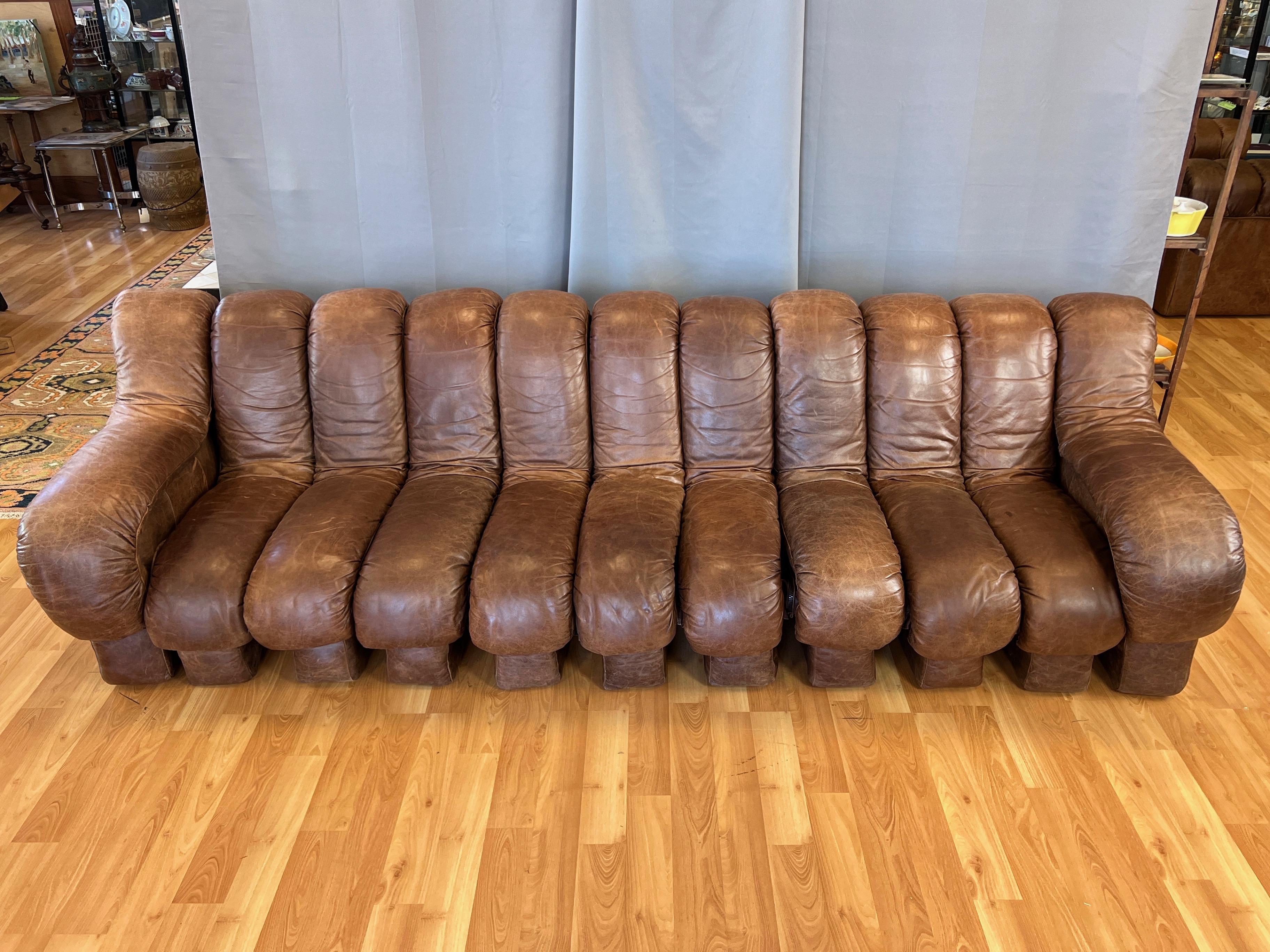 A 1970s nine-foot-long eleven-element de Sede DS-600 Snake sofa in original light brown leather, designed by Ueli Berger, Elenora Peduzzi-Riva, Heinz Ulrich, and Klaus Vogt.

Officially designated as the “Snake” sofa by de Sede, the Swiss company