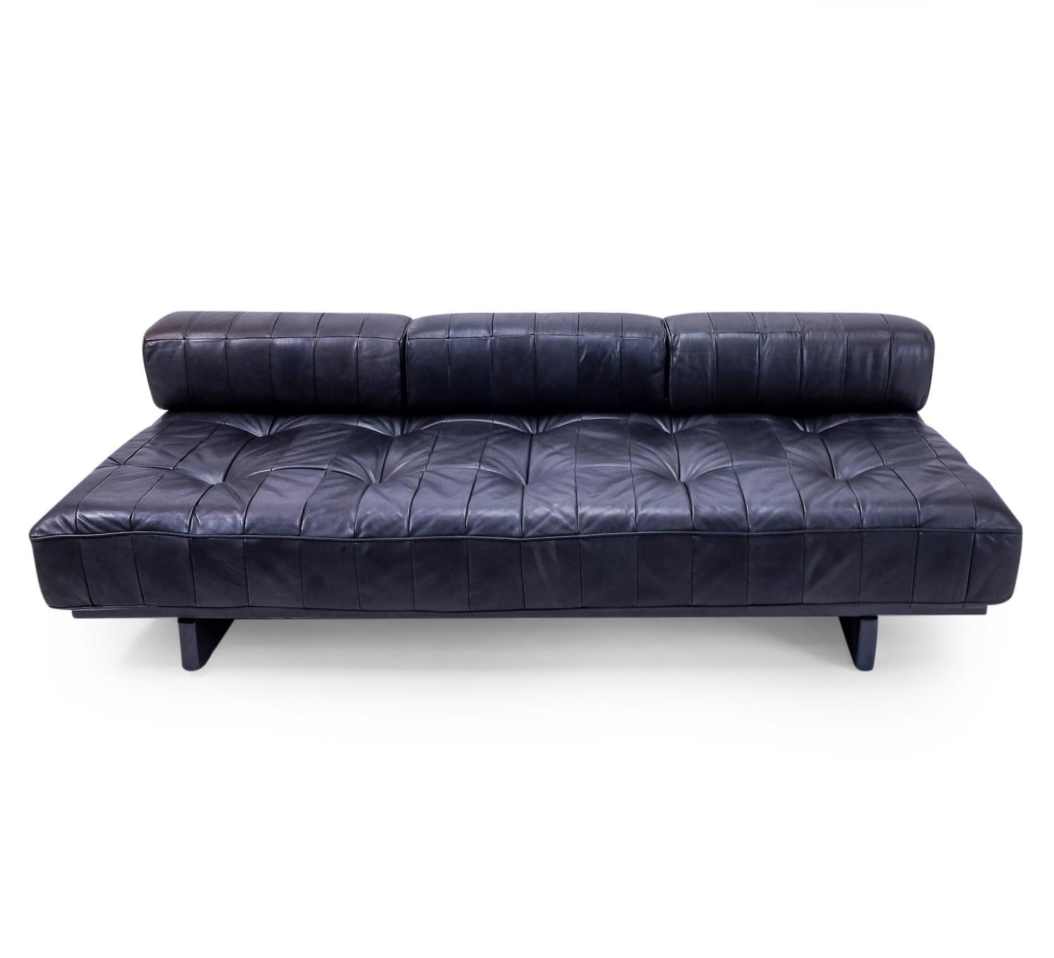 De Sede Daybed model DS 80 in a nice patined black leather, featuring 3 pillows. We have the same daybed available with an additional pillow.

The leather is a patchwork design made from black pigmented aniline leather, which typically gives a