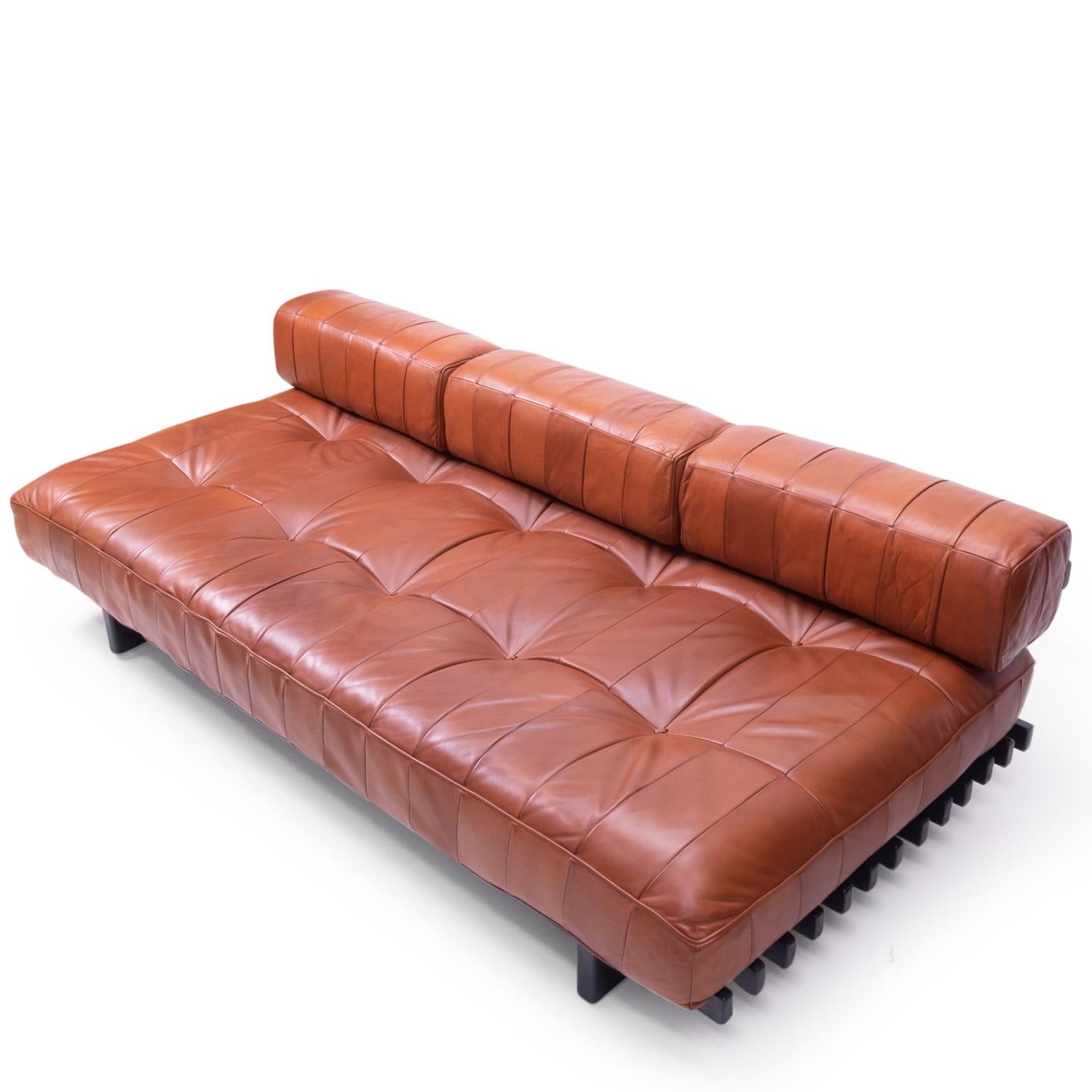 De Sede Daybed model DS 80 in a warm brown leather, featuring a wonderful patine and comes with 3 pillows.

The leather is a patchwork design made from pigmented aniline leather, which typically gives a very “lived” look due to the open nature of