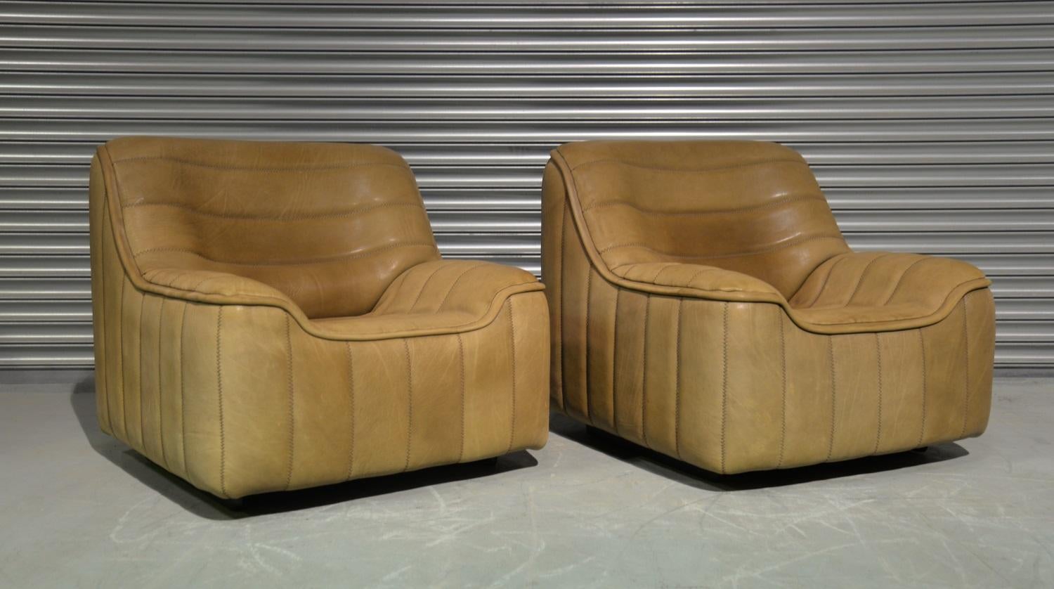 We are delighted to bring to you a pair of ultra rare vintage De Sede DS 84 armchairs. Hand built in the 1970s by De Sede craftsman in Switzerland, these pieces are upholstered in thick beige neck leather with superb stitch detail. The pieces are