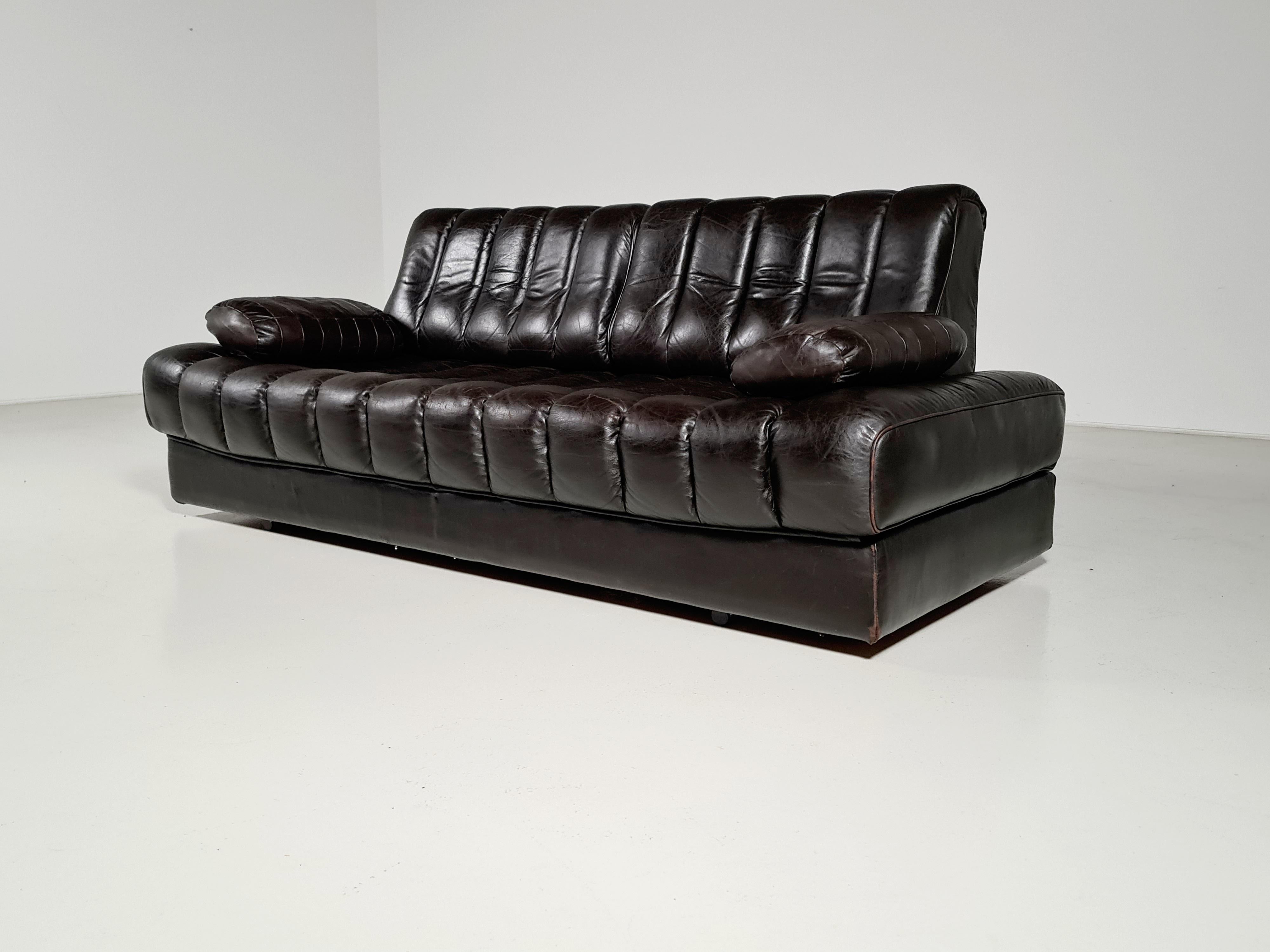 Beautiful vintage leather De Sede DS-85 versatile daybed sofa in a dark brown color with patina. Can be used as a daybed or opens up into a larger double bed. This unique vintage De Sede sofa daybed made in Switzerland, circa 1970s is in good