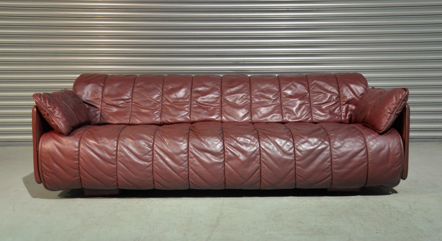 We are delighted to bring to you an rare vintage De Sede sofa or daybed. Made by De Sede craftsman in Switzerland, this convertible sofa or daybed is upholstered in beautiful burgundy quilted aniline leather with two occasional cushions. It`s