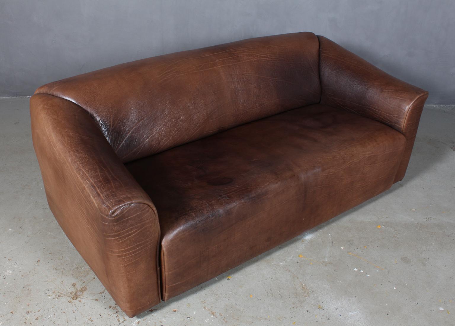 Highly comfortable DS47 sofa patinated leather by De Sede. The design is simplistic, yet very modern. A tight and cubic outside with a soft and curved inside, which emphasize the comfortable character of this set. The thick leather is laid in one