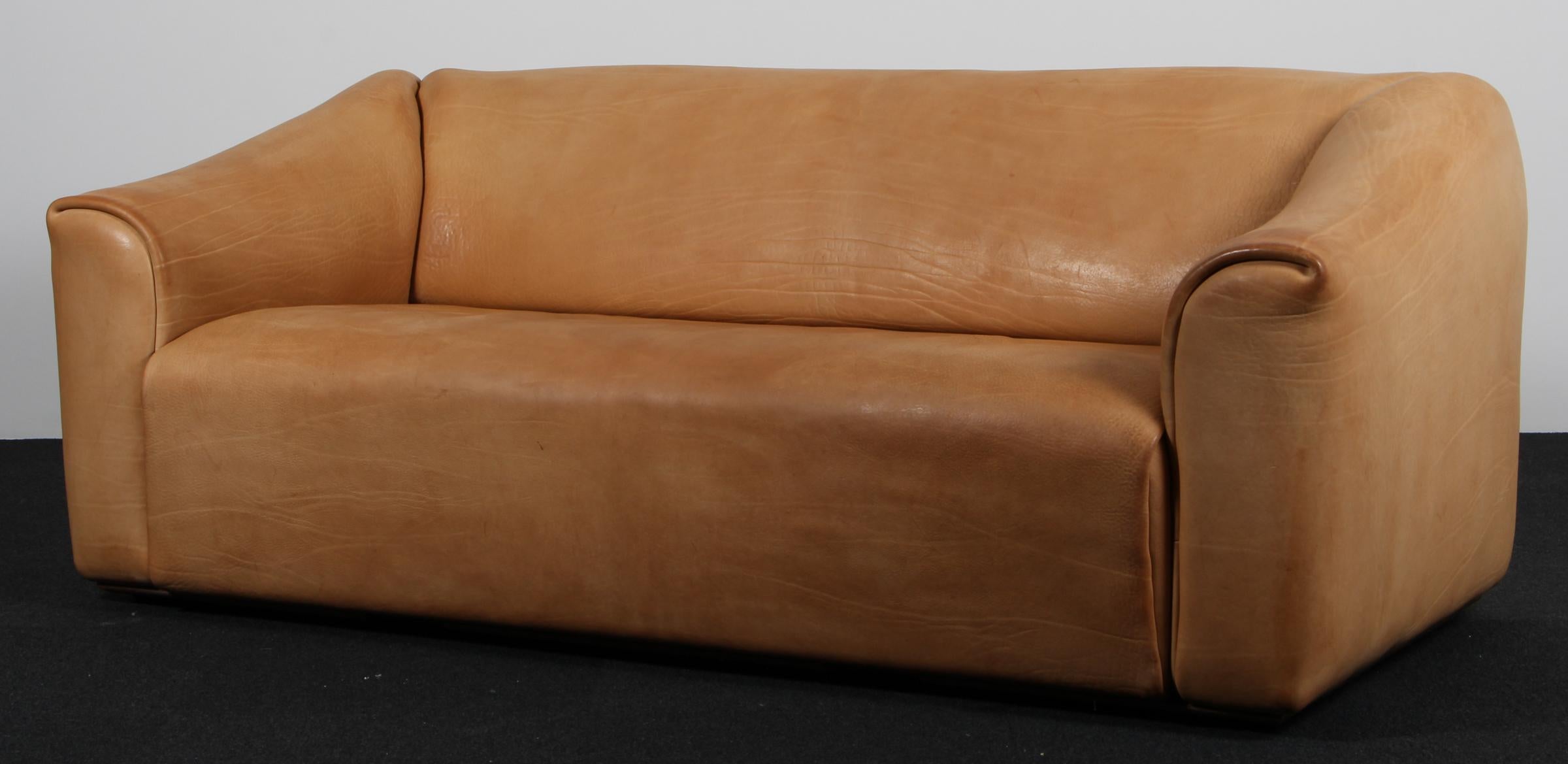 Canapé très confortable DS47 en cuir patiné par De Sede. Le design est simpliste, mais très moderne. Un extérieur étroit et cubique avec un intérieur doux et incurvé, qui souligne le caractère confortable de cet ensemble. Le cuir épais est posé en