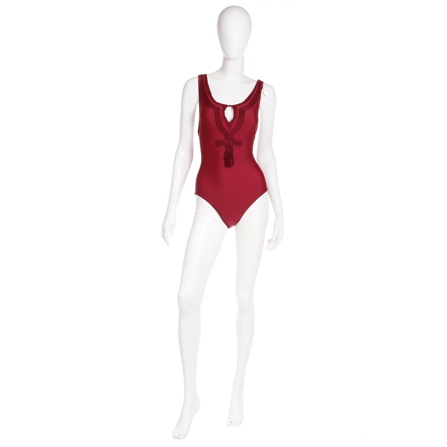 This incredible vintage Jean Paul Gaultier swimsuit was never worn and still has its original tags attached! The one piece suit is in a rich burgundy red and it has gorgeous soutache embroidery with fringe. The front has a single button closure